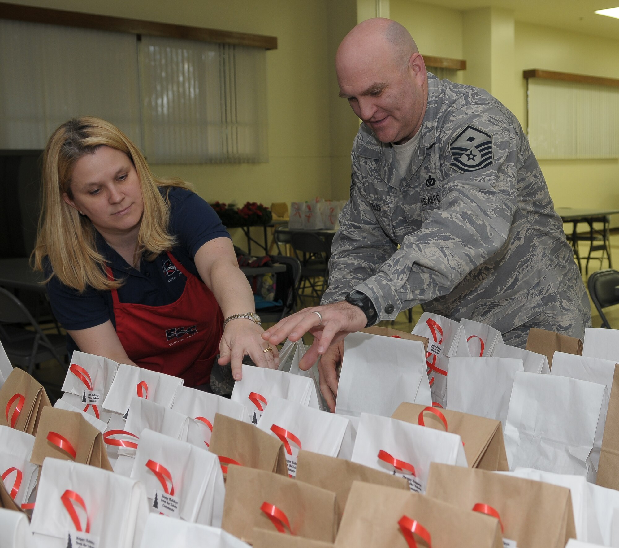 YOKOTA AIR BASE, Japan -- Nanette Mills, Yokota Enlisted Spouses Club member, and Master Sgt. Michael Strickler, 374th Medical Group first sergeant, count bags of cookies for Airmen Dec. 18 during the Cookie Crunch event. More than 3,000 cookies were donated, bagged and distributed to Airmen in the dormitories by the YESC. (U.S. Air Force photo/Airman 1st Class Sean Martin)