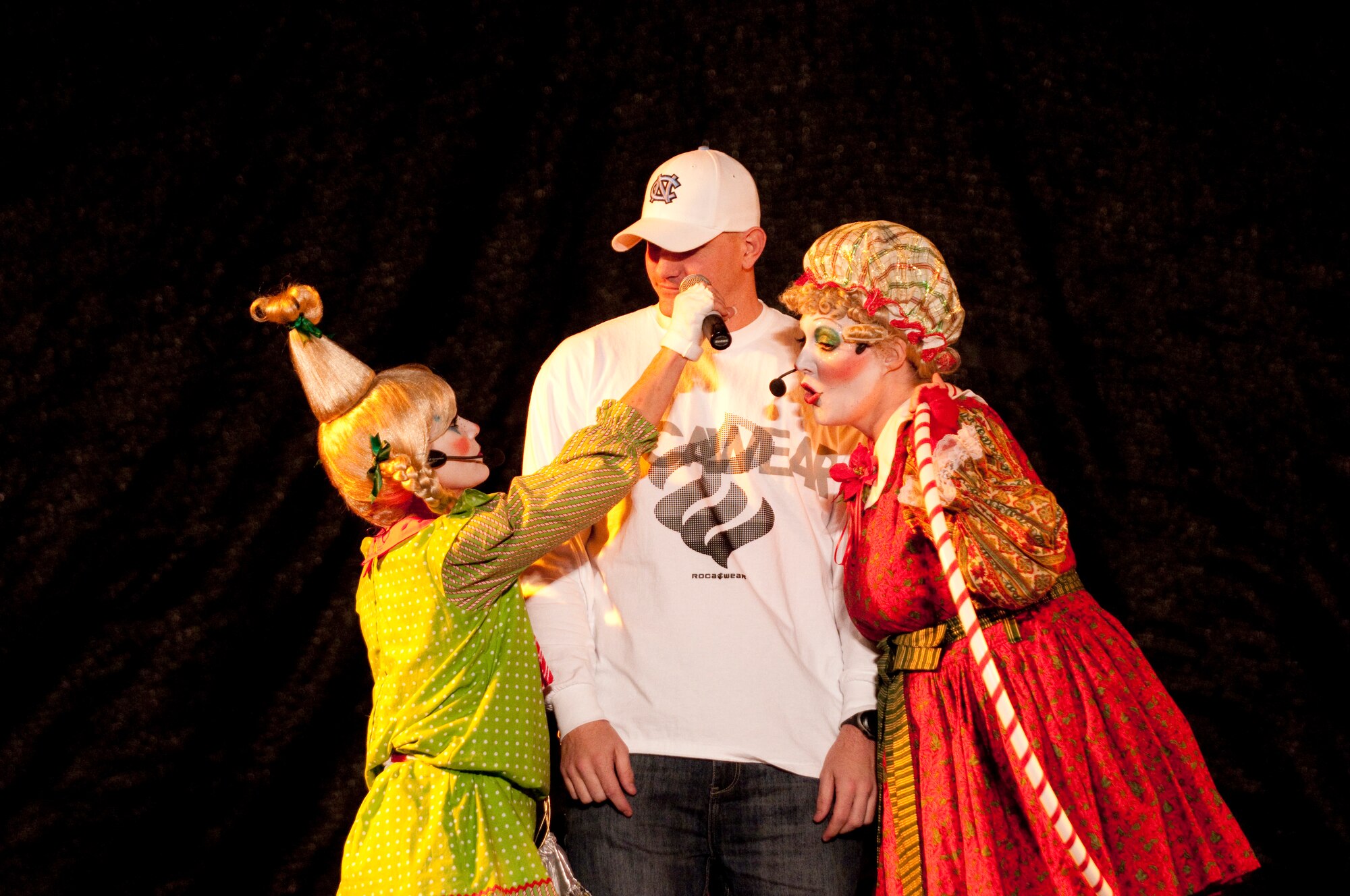 KUNSAN AIR BASE, Republic of Korea -- Master Sgt. Warren Benge, 8th Force Support Squadron first sergeant gets pointers from the Cirque Dreams Holidazes narrators right before participating in a holla-hoop contest here Dec. 8. The Cirque Dreams Holidaze show, which was brought here as part of the Pacific Armed Forces Entertainment tour, featured an international cast of acrobats, aerialists and dancers displaying the wonders of the holidays. (U.S. Air Force photo by/ Senior Airman Jonathon Steffen)