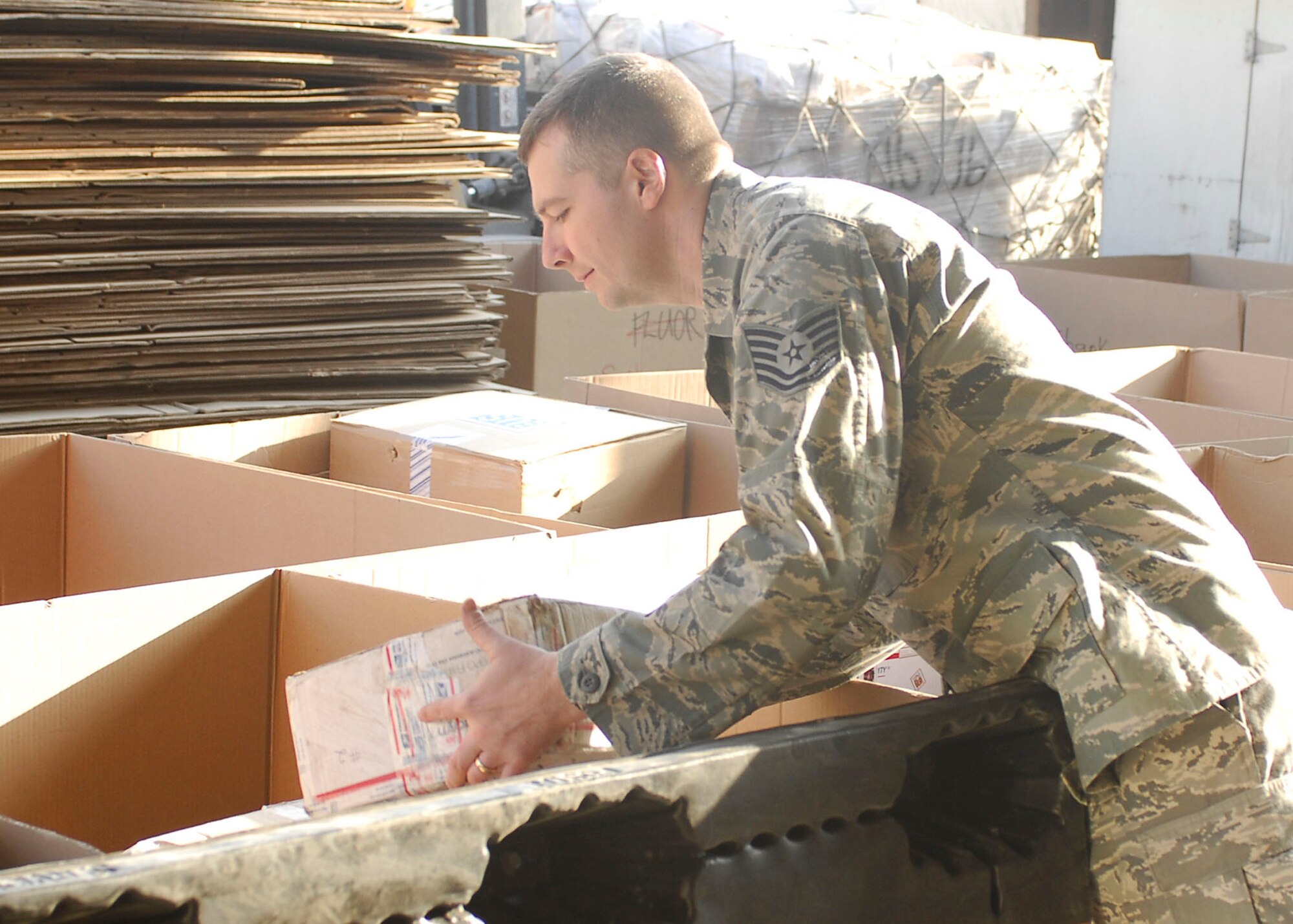 BAGRAM AIRFIELD, Afghanistan -- Tech. Sgt. Anthony Myers, a personnelist from the 38th Human Resources Company, assists the post office with sorting mail to be sent to Forward Operating Bases, Dec. 20, 2009 The post office receives more mail than usual and needs a couple extra hands to get the mail delivered on time during the holiday season. Sergeant Myers is deployed from Randolph Air Force Base, Texas and hails from Kosciusko, Miss.  (U.S. Air Force photo/Senior Airman Felicia Juenke)