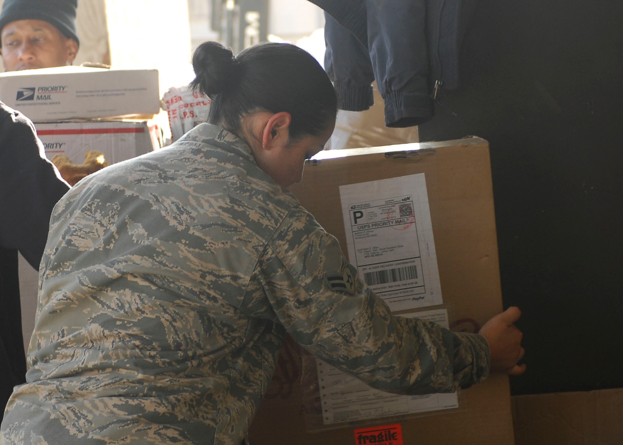 BAGRAM AIRFIELD, Afghanistan -- Airman 1st Class Guadalupe Quinonez, a personnelist from the 38th Human Resources Company, assists the post office with sorting mail to be sent to Forward Operating Bases, Dec. 20, 2009.  The post office receives more mail than usual and needs a couple extra hands to get the mail delivered on time during the holiday season.  Airman Quinonez is deployed from Hill Air Force Base, Utah and hails from Bloomington, Calif.  (U.S. Air Force photo/Senior Airman Felicia Juenke)