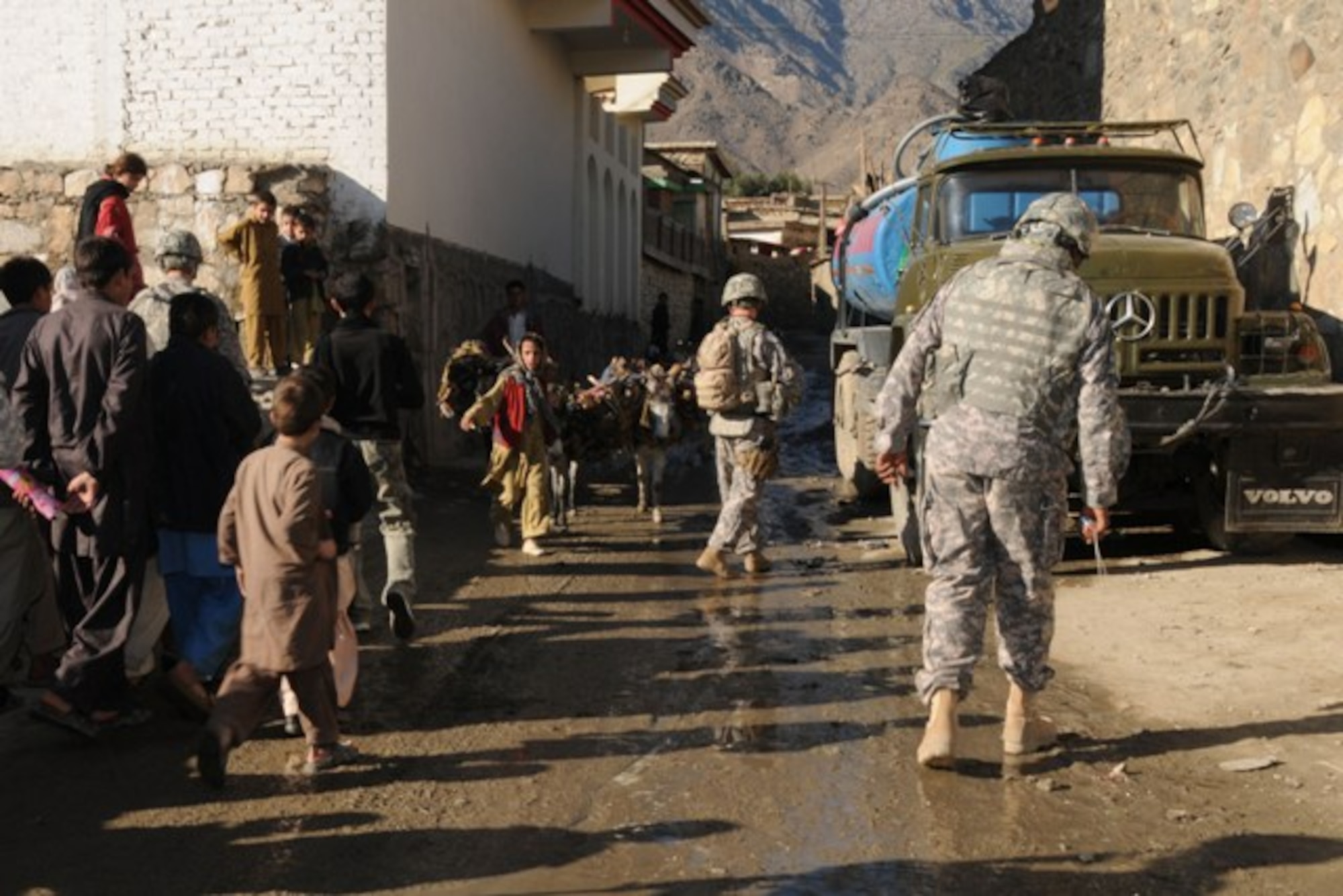 KUNAR PROVINCE, Afghanistan – Local Afghans in downtown Asadabad watch a Provincial Reconstruction Team-Kunar patrol conduct a final quality assurance and quality check of a new 4-kilometer road through the provincial capital prior to a dedication ceremony, recently. The Provincial Reconstruction Team-Kunar engineers did the check to ensure the Kunar Construction Company did a good job building the road. The project took nearly one year and approximately $1 million to complete. The hope for the new road is it will continue to spur economic development and job growth in the city. More than 50 provincial leaders and tribal elders gathered at the ceremony site after the QA/QC check to do the ribbon cutting ceremony. (U.S. Air Force photo/Tech. Sgt. Brian Boisvert)