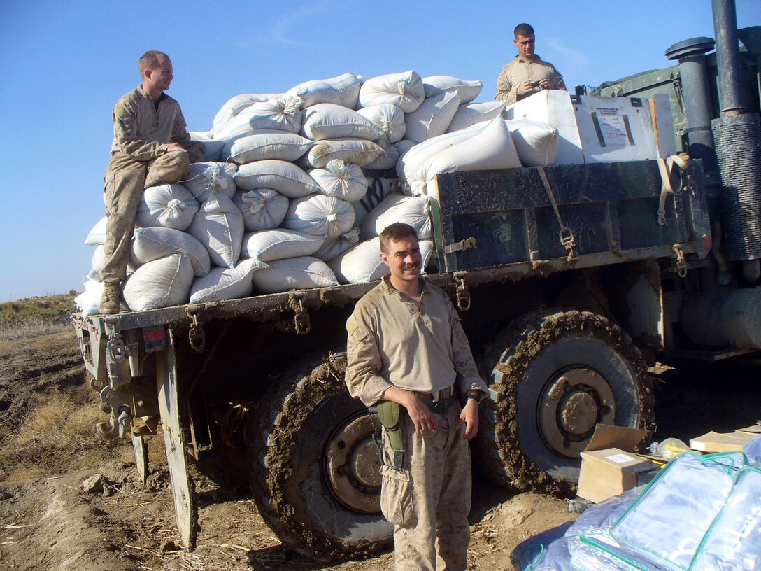 Capt. Christopher Banweg (front) and Maj. Jeremy Hoffmann prepare to assist in a distribution of wheat seed and blankets in the village of Qual E Now here Dec. 18, 2009.  The wheat seed is a part of an alternative crop program to wean the people off of poppy cultivation.  Banweg is a member of 4th Civil Affairs Group, a Marine Forces Reserve unit headquartered in Washington, D.C.  A career reserve Marine, Banweg perated with his team here from November 2009 to May 2010, spearheading key infrastructure development projects.