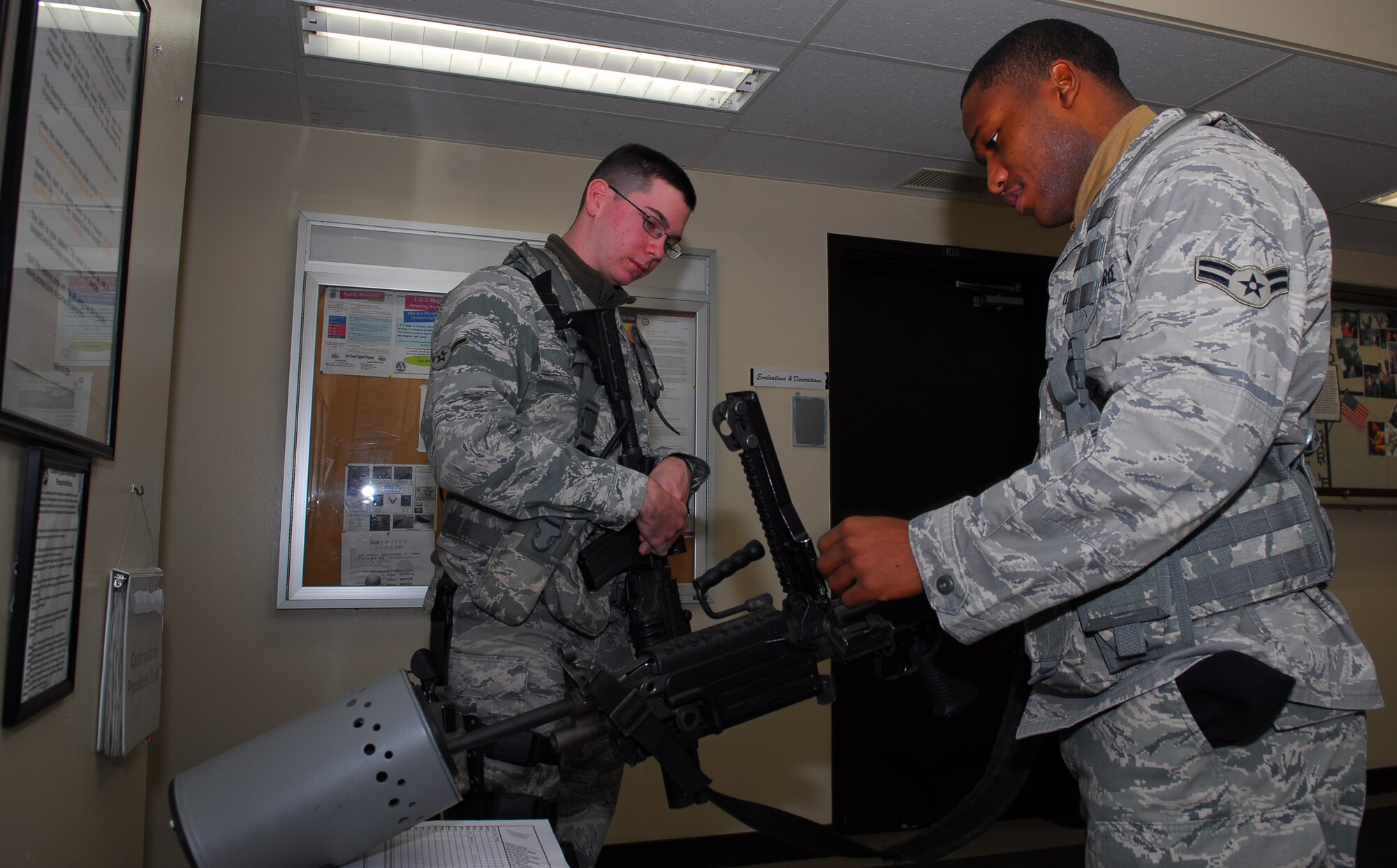 MISAWA AIR BASE, Japan – Airman Jarrod Chambers, 35th Security Forces Squadron patrolman, assists Airman 1st Class Leday Adam, 35th SFS patrolman, inspects a 249B squad automatic weapon Dec. 18, during guard mount at the security forces building. The 249B SAW replaced the M-60 automatic rifle. (U.S. Air Force photo/Staff Sgt. Phillip Butterfield)