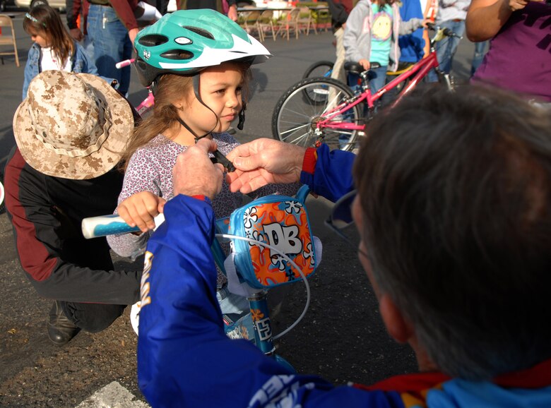 LOMPOC, Calif. -- Getting her helmet fitted, Briana Cassim, daughter of Tech. Sgt. Shawn Cassim, receives bike gear during the Christmas Bikes for Kids Saturday, Dec. 19, 2009, here. The Christmas Bikes program provides bikes and helmets to families of Vandenberg deployed servicemembers. (U.S. Air Force photo/Airman 1st Class Kerelin Molina)