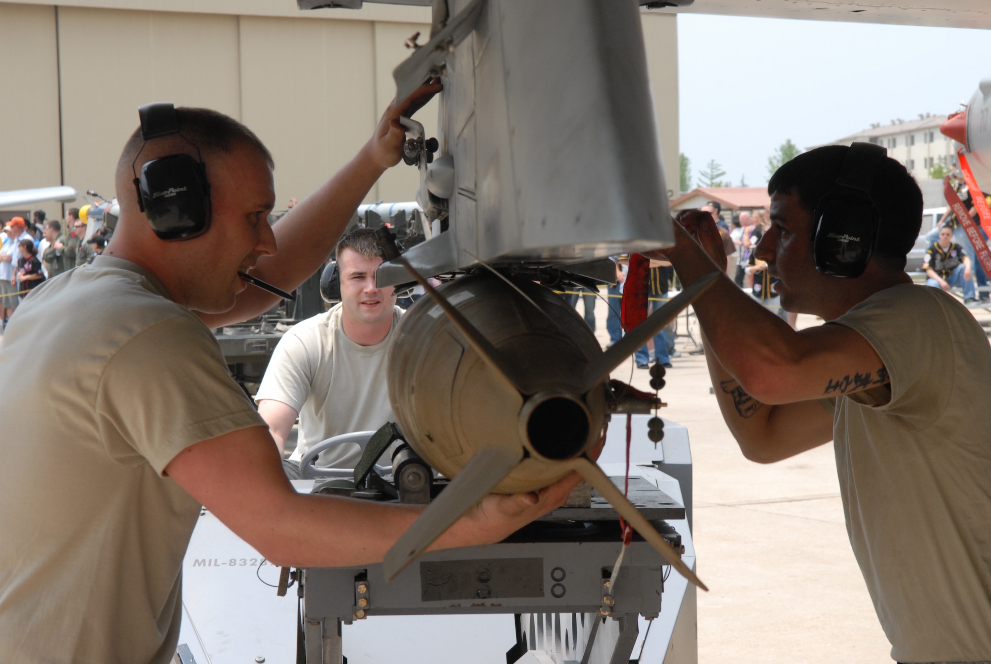 (Left to right) Staff Sgt. Matt Simpson, Senior Airman Brandon Harrelson and Senior Airman Bobby Pelotte, all members of the weapons loading team representing Kunsan Air Base, Republic of Korea, secure an MK-82 to an F-16 bomb rack May 30, during the peninsula-wide weapons load competition here. Teams from Misawa Air Base, Japan, Osan Air Base, ROK, Kunsan AB, and the Republic of Korea Air Force participated in the competition. (U.S. Air Force photo by Staff Sgt. Patrice Clarke)