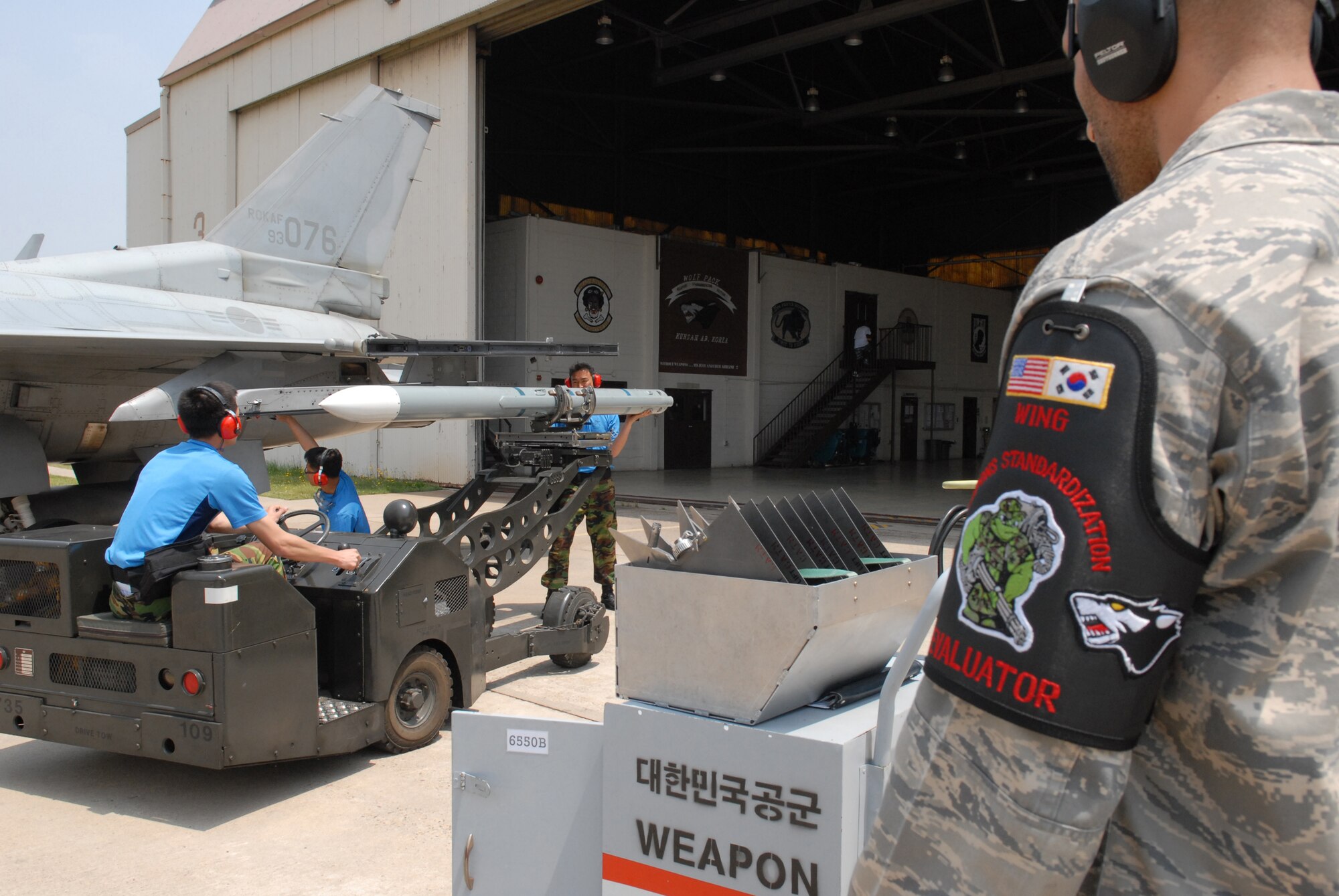 Staff Sgt. Rafael Gabrial, 8th Maintenance Operations Squadron, evaluates the Republic of Korea Air Force weapons load team during the peninsula-wide weapons load competition May 30, at Kunsan Air Base, Republic of Korea. Evaluators from Misawa Air Base, Japan, Osan Air Base, ROK, Kunsan AB and the ROKAF were all on hand to judge the competition. (U.S. Air Force photo by Staff Sgt. Patrice Clarke)