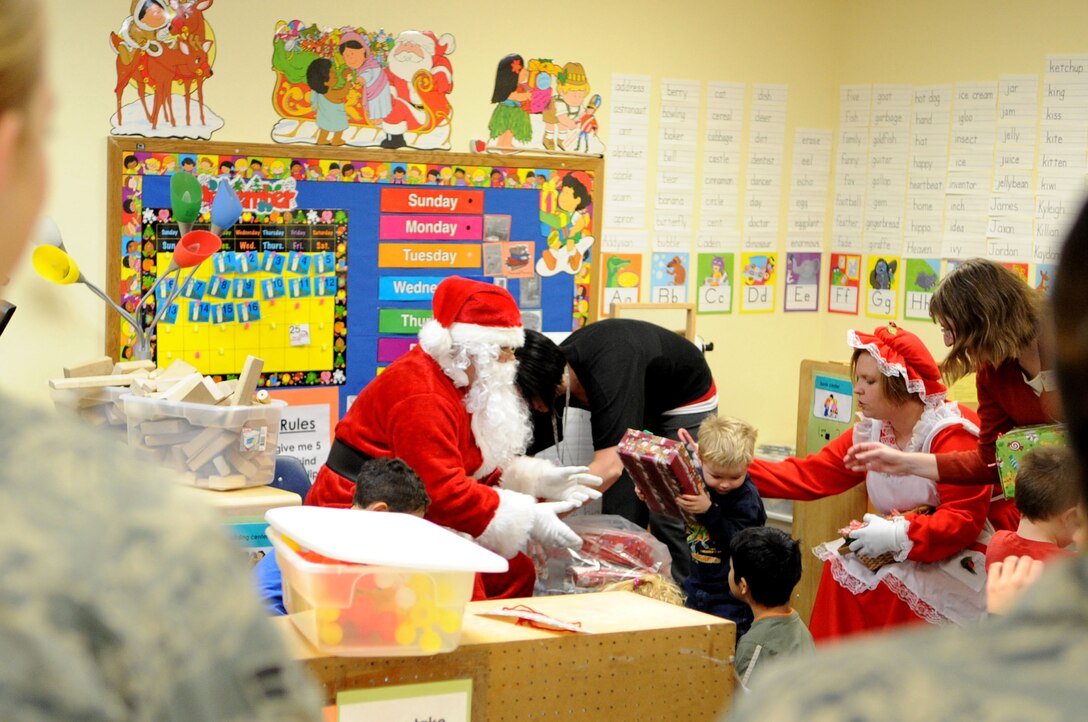ELLSWORTH AIR FORCE BASE, S.D.-- Children receive presents at the Youth and Family Services child care center in Rapid City, S.D., Dec. 17. YFS staff provided the names and ages of infants, toddlers and preschool-aged children in their program to 28th Operations Group members, who then purchased and wrapped gifts for every child. (US Air Force photo/Airman 1st Class Corey Hook)