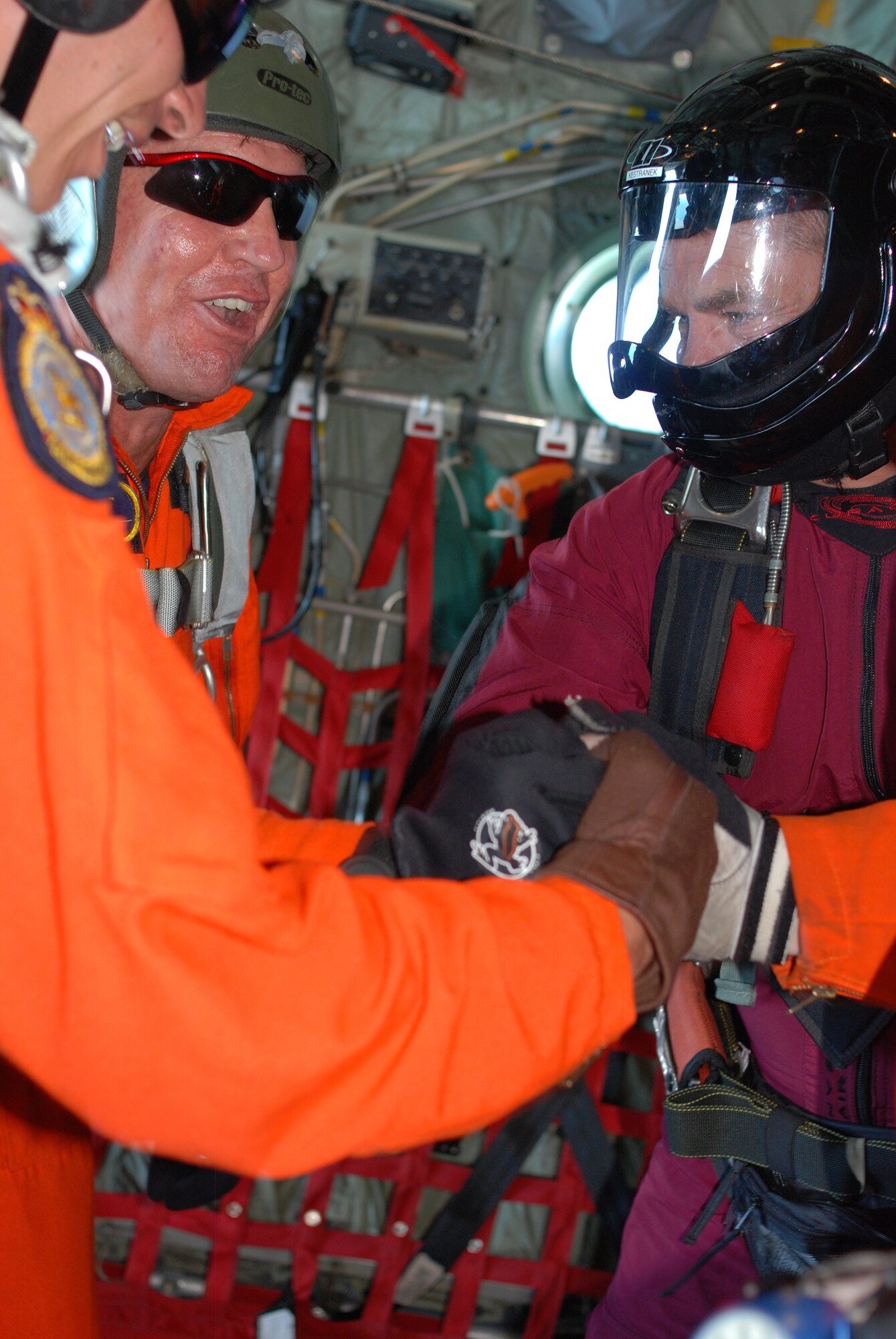 Key West, Fla. - It was a group jump during the 2009 SAREX in Key West. In the orange flight suits, the Canadian SARTechs show Chief Master Sgt. Doug Kestranek, PJ with the 920th RQW, their salute before the joint HALO jump. Both the American and Canadian teams are fully parachute qualified and ready to deploy on a life saving mission at a moment's notice. (U.S. Air Force Photo/Staff Sgt. Leslie Kraushaar)