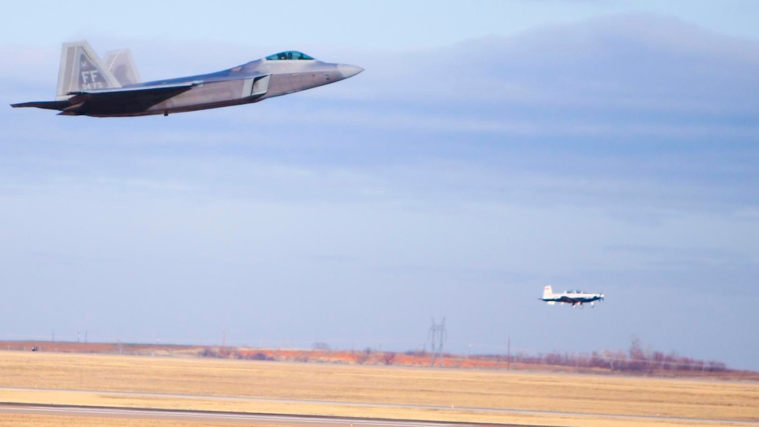 Col. Matthew "Zap" Molloy, commander of the 1st Fighter Wing at Langley Air Force Base, Va., makes a low-level pass Dec. 17 in an F-22/A Raptor during his arrival to the 80th Flying Training Wing as a T-6A Texan IIcomes in for a landing. The colonel was the guest speaker Dec. 18 at the graduation of Euro-NATO Joint Jet Pilot Training Program Class 10-02. (U.S. Air Force photo/Lt. Col. Ternell Washington)
