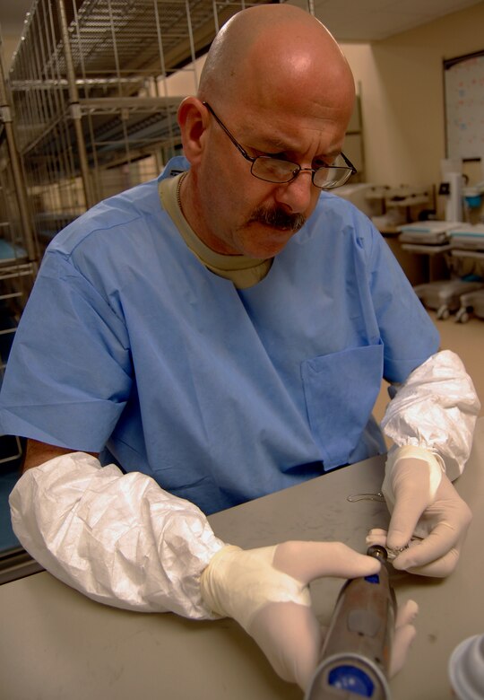 U.S. Air Force Tech. Sgt. Gary Fernandes, 914th Services Squadron, uses a rotary tool
to clean a religious medal so it can be returned to a fallen servicemember's
family.  Sergeant Fernandes and 13 other 914th SVS members are deployed to
the Air Force Mortuary Affairs Operations Center at Dover Air Force Base,
Del., where they help provide dignity, honor and respect for the fallen, as
well as care, service and support for their family members.  U.S. Air Force
photo by Ed Drohan.
