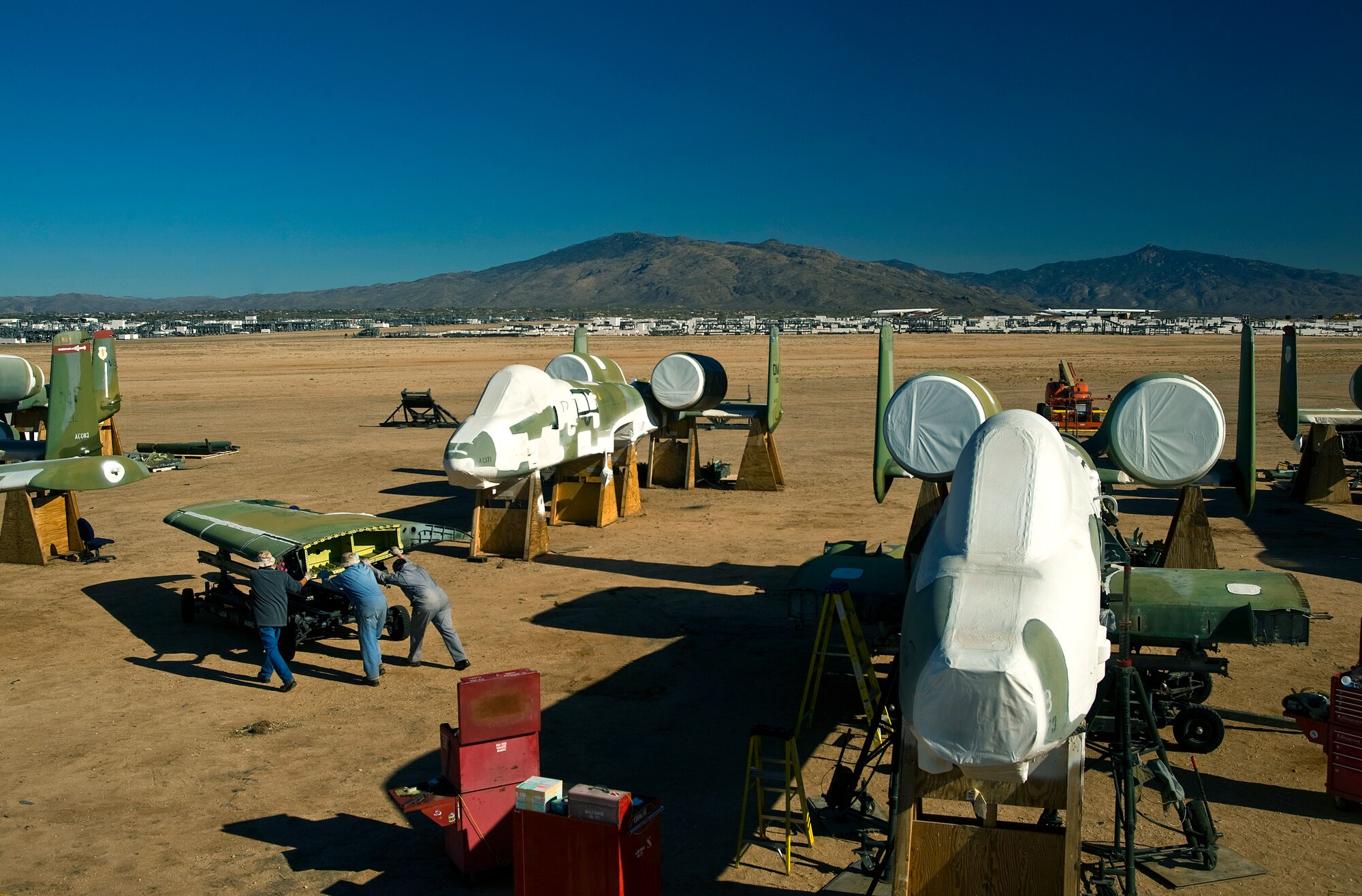 Aircraft mechanics wheel away the wings of an A-10 Thunderbolt II that has been sitting in the 309th Aerospace Maintenance and Regeneration Group "Boneyard" at Davis-Monthan Air Force Base, Ariz.  The wings were removed Dec. 17, 2009, to undergo strengthening modifications as part of an A-10 wing upgrade that will increase the service life of the aircraft another 8,000 hours in the air. (U.S. Air Force photo/Staff Sgt. Bennie J. Davis III)