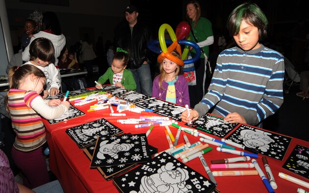 Team McConnell children color holiday puzzles, Dec. 12, 2009, during a Santa visit at the Robert J. Dole Center The holiday event features seasonal music and games for more than 650 family members who attended.  (U.S. Air Force Photo/Airman 1st Class Ruiz) 