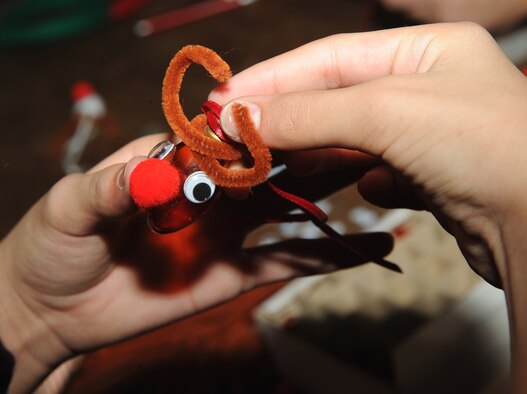 A Team McConnell family member makes a reindeer ornament out of a light bulb, Dec. 12, 2009, during Santa’s visit at the Robert J. Dole Center at McConnell Air Force Base, Kan. Crafts were among several activities available for families at the holiday event. (U.S. Air Force Photo/Airman 1st Class Ruiz)