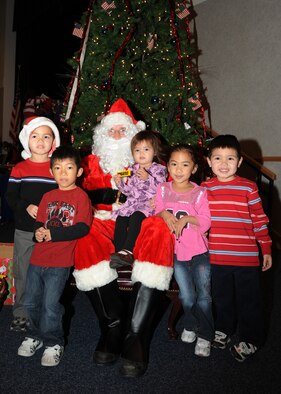 Team McConnell children take a photo with Santa, Dec. 12, 2009, during his visit to McConnell Air Force Base, Kan. Family members who met Santa at the Robert J. Dole Center received a free photo with him, a chance to win prizes and free donuts, drinks and crafts. (U.S. Air Force Photo/Airman 1st Class Ruiz)