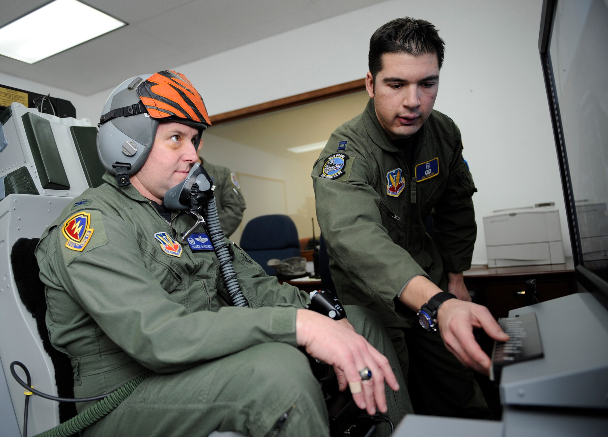 MOUNTAIN HOME AIR FORCE BASE, Idaho -- Capt. Joseph Pugliese, 366th Aerospace Medicine Squadron aerospace and operational physiologist, briefs Col. James McGovern, 366th Operations Group commander, on the first on base sim-based hypoxia demo for fighter aircrew Dec. 16. The simulators help familiarize aircrew with the physiological and psychological stresses of flight. Without the aid of an oxygen mask aircrew experience symptoms of hypoxia, an oxygen deficiency of the tissue and blood cells that causes impairment of function at high altitudes. (U.S. Air Force photo by Airman 1st Class Renishia Richardson)