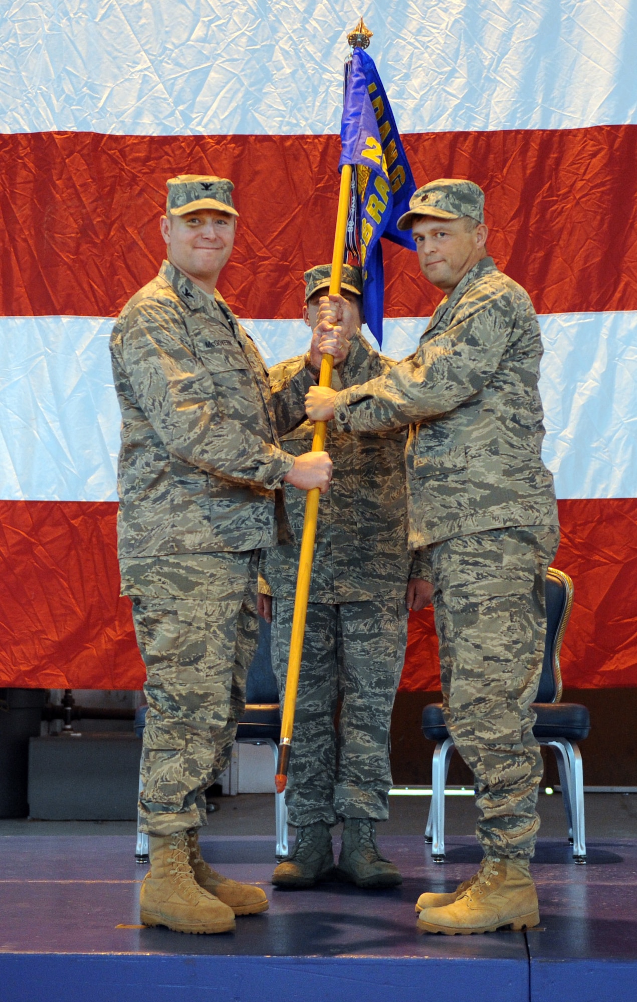 MOUNTAIN HOME AIR FORCE BASE, Idaho -- Col. James McGovern, 366th Operations Group commander, passes the 266th Range Squadron guidon to Lt. Col. William Michell during a change-of-command ceremony Dec. 15 in hangar 201. Colonel Michell received command from Lt. Col. Derek Newland. (U.S. Air Force photo by Airman 1st Class Debbie Lockhart)