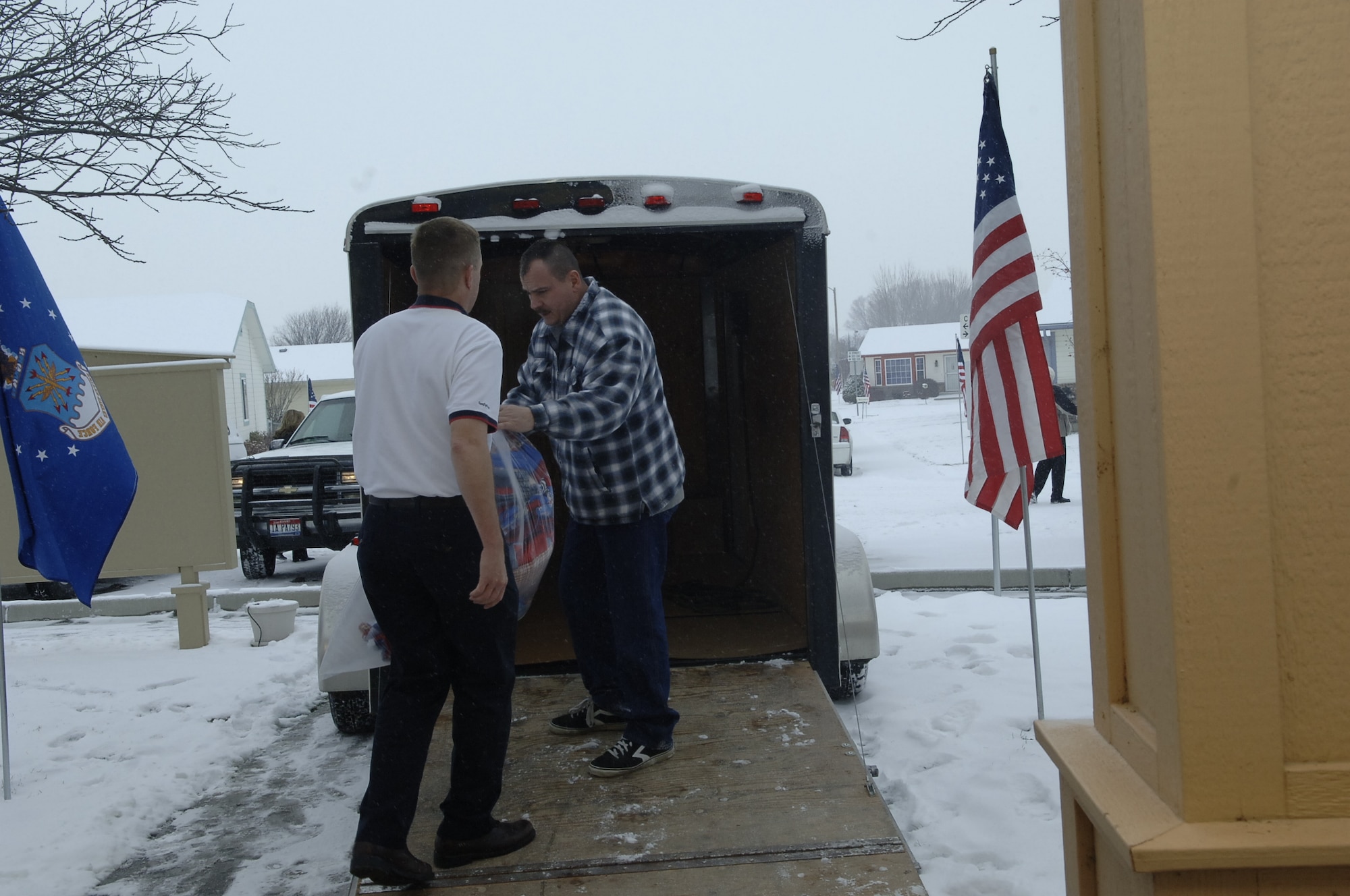 MOUNTAIN HOME AIR FORCE BASE, Idaho --Col. Pete Lee, 366th Fighter Wing vice commander, hands handmade quilts to Master Sgt. Mark Muster, 366th Civil Engineer Squadron first sergeant, to load into a trailer after the Silver Crest II Annual Holiday Social in Nampa, Idaho, Dec. 12. Two members of the retirement community, Rita and Bud Albers, have put together this event for nine years. This year more than $13,000, hundreds of toys and quilts, and 2,000 pounds of food were donated to Operation Warmheart to help military families during the holiday season. (U.S. Air Force photo by Staff Sgt. Jasmine Reif)