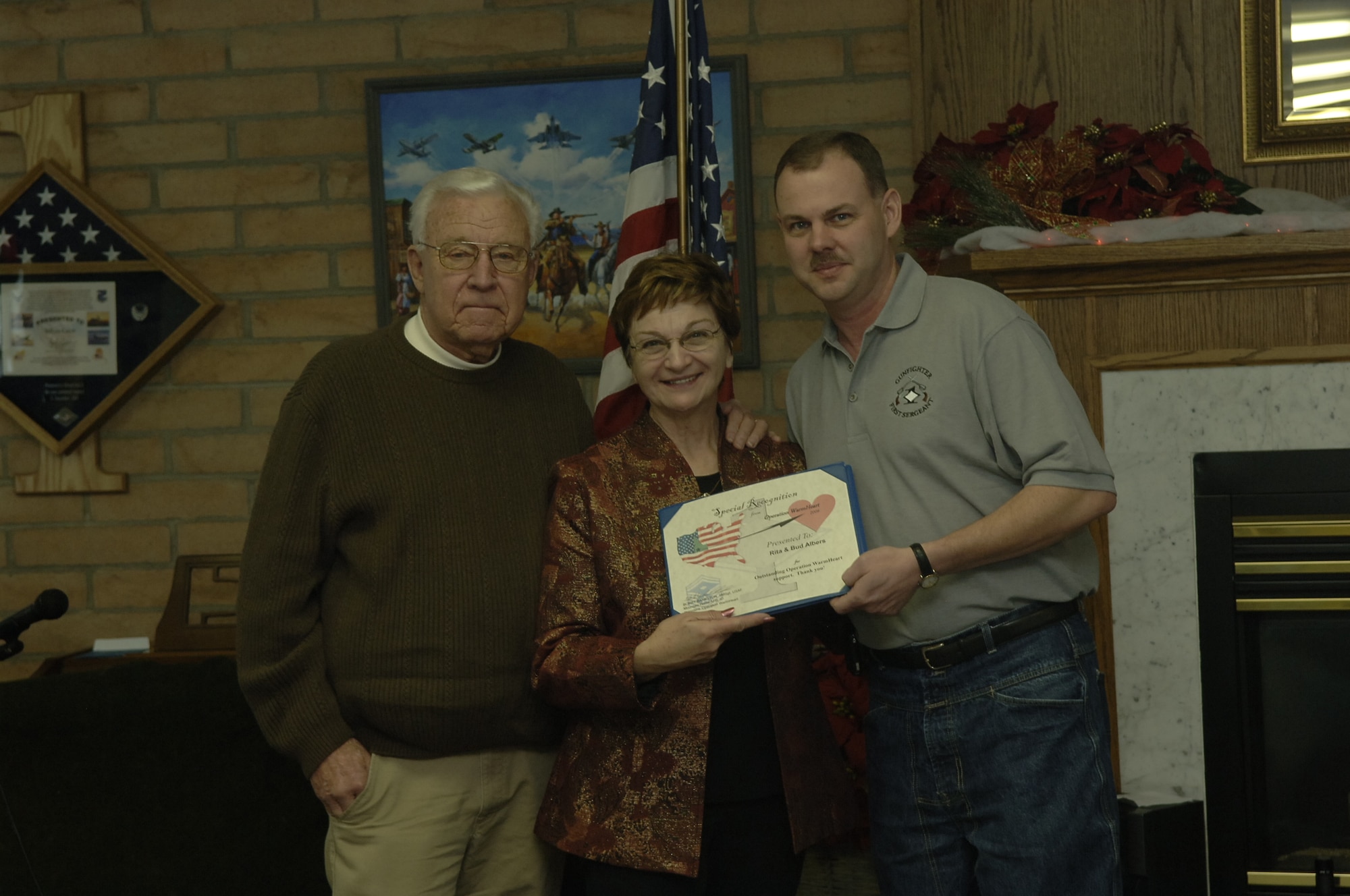 MOUNTAIN HOME AIR FORCE BASE, Idaho --Rita and Bud Albers receive a certificate from Senior Master Sgt. Bobby Bankston, Operation Warmheart president, during the Silver Crest II Annual Holiday Social in Nampa, Idaho, Dec. 12. They have put together this event for the past nine years. This year more than $13,000, hundreds of handmade toys and quilts, and 2,000 pounds of food were donated to Operation Warmheart to help military families during the holiday season. (U.S. Air Force photo by Staff Sgt. Jasmine Reif)