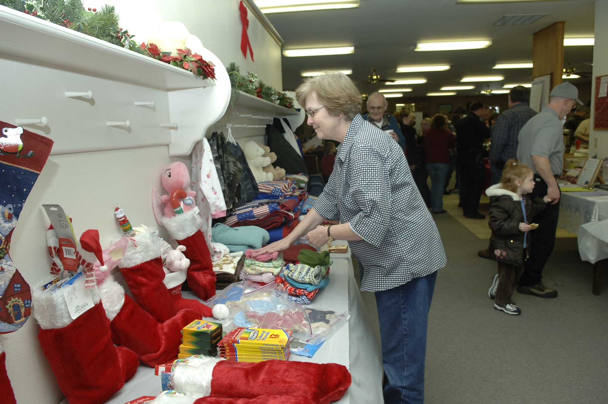 MOUNTAIN HOME AIR FORCE BASE, Idaho --Diana Hill looks at the many donations displayed during the Silver Crest II Annual Holiday Social in Nampa, Idaho, Dec. 12. Every year Mrs. Hill’s family donates money to Operation Warmheart at this event in memory of her mother. Two members of the retirement community, Rita and Bud Albers, have put together this event for nine years. This year more than $13,000, hundreds of toys and quilts, and 2,000 pounds of food were donated to Operation Warmheart to help military families during the holiday season. (U.S. Air Force photo by Staff Sgt. Jasmine Reif)