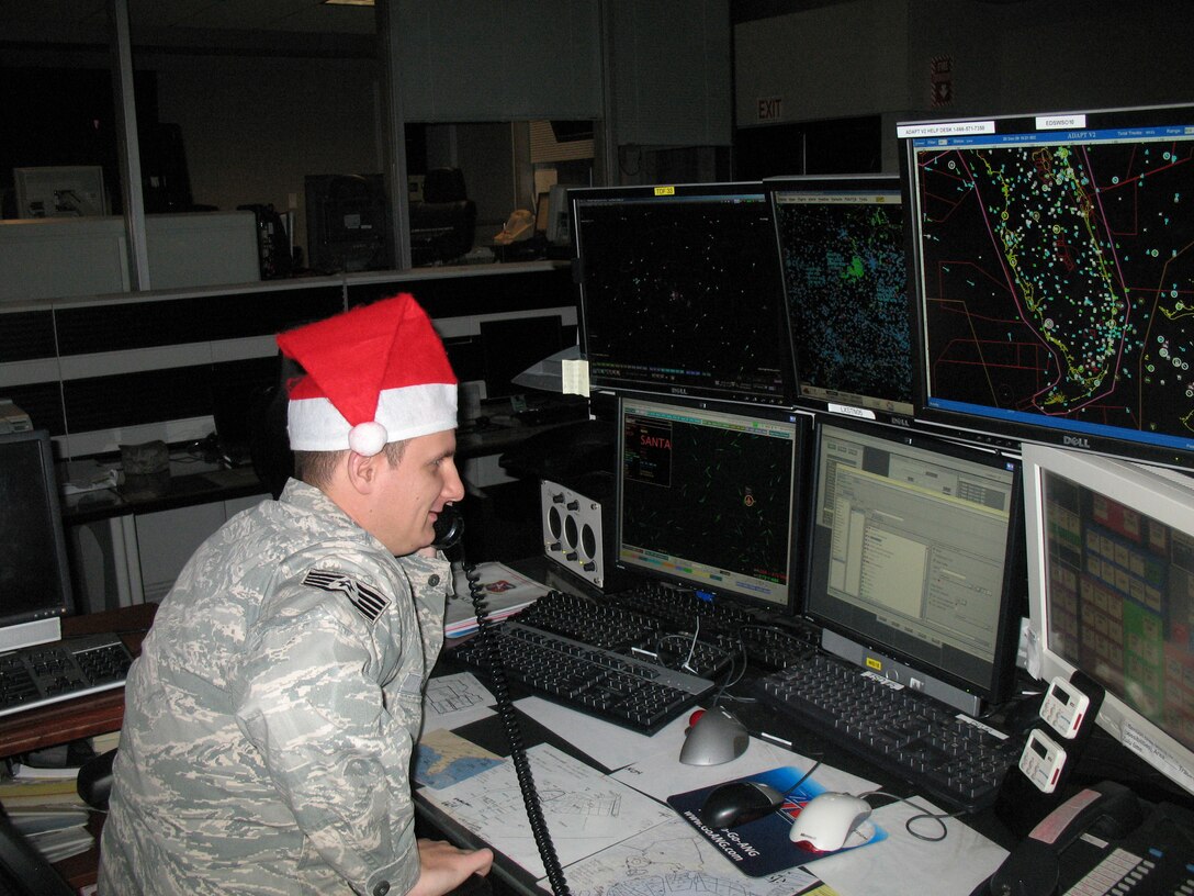 Staff Sgt. Jason Cole, Eastern Air Defense Sector Alpha flight member, chats with one of Santa?s helpers at the North Pole. The air defense controllers at EADS will track Santa Claus over the eastern U.S. during his Christmas Eve journey across the nation. EADS personnel will work diligently through the night on Christmas Eve to maintain ongoing contact with Santa as he continues his travels across the states (U.S. Air Force photo by Brooke Davis).