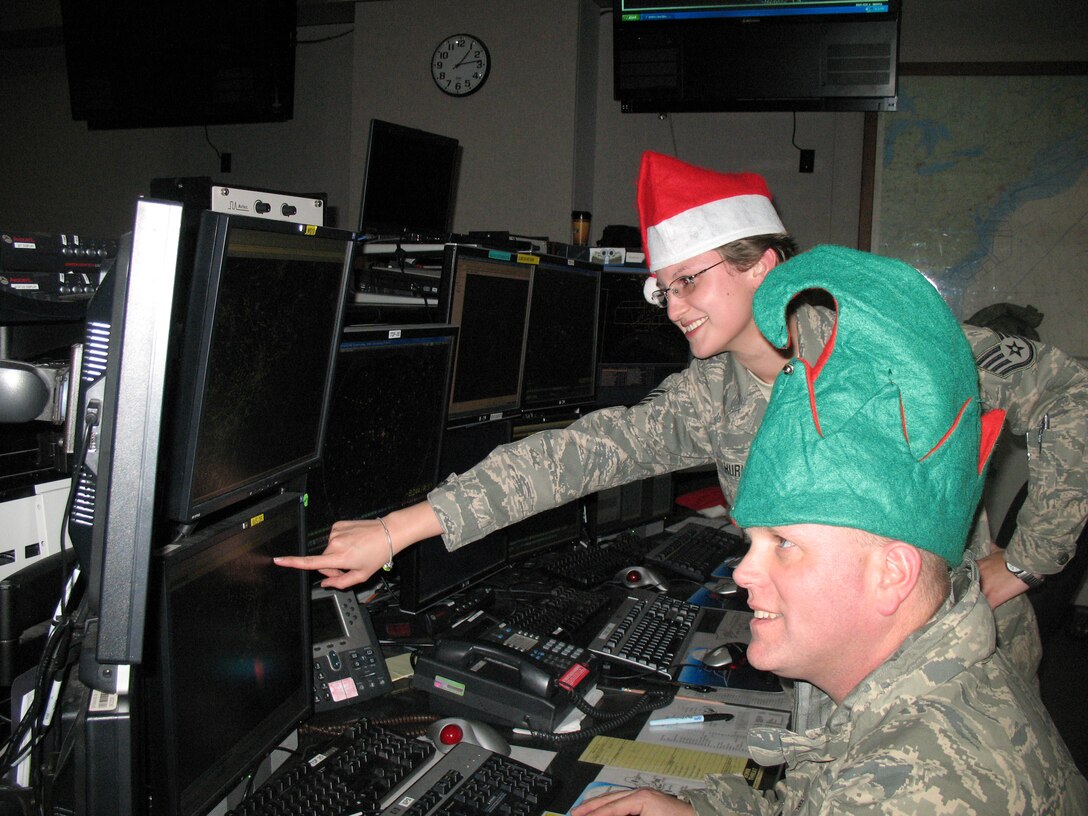 Staff Sgts. Karen Hurley and Corey Reynolds, both members of the Eastern Air Defense Sector?s Alpha flight, take a peek at Santa?s progress in the North Pole. The air defense controllers at EADS will track Santa Claus over the eastern U.S. during his Christmas Eve journey across the nation. EADS personnel will work diligently through the night on Christmas Eve to maintain ongoing contact with Santa as he continues his travels across the states (U.S. Air Force photo by Brooke Davis).