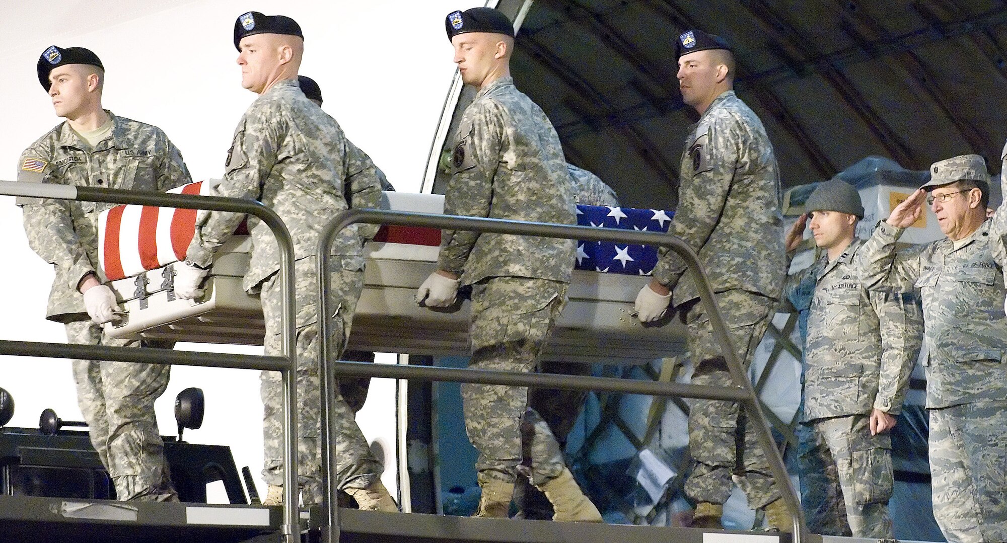 Chaplain (Lt. Col.) Lance Jennings (back right) salutes during a dignified transfer at Dover Air Force Base, Del. In one of his many roles at the Air Force Mortuary Affairs Operations Center, Chaplain Jennings offered a prayer for the fallen Soldier. USAF Photo by Jason Minto.  
