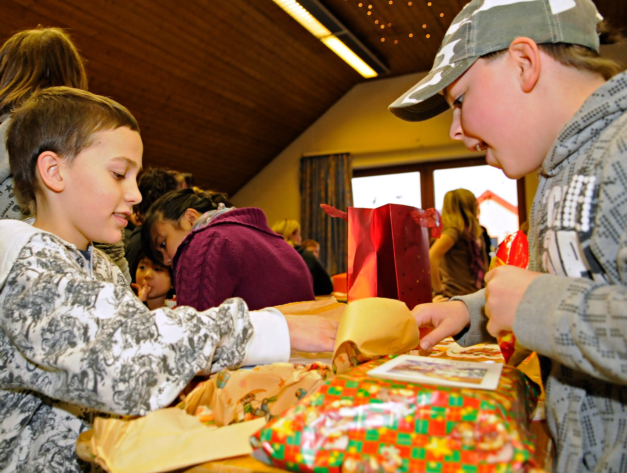 SPANGDAHLEM AIR BASE, Germany – Yannick Felix (left) and Tobias Werneco open gifts during a Christmas party Dec. 18 at the St. Vinzenshaus Orphanage in Speicher, Germany. The 52nd Security Forces Squadron donated 60 gifts to the orphanage to help the children celebrate Christmas. The 52nd SFS has been donating gifts to St. Vinzenshaus twice a year for the past three years. (U.S. Air Force photo/Senior Airman Benjamin Wilson)