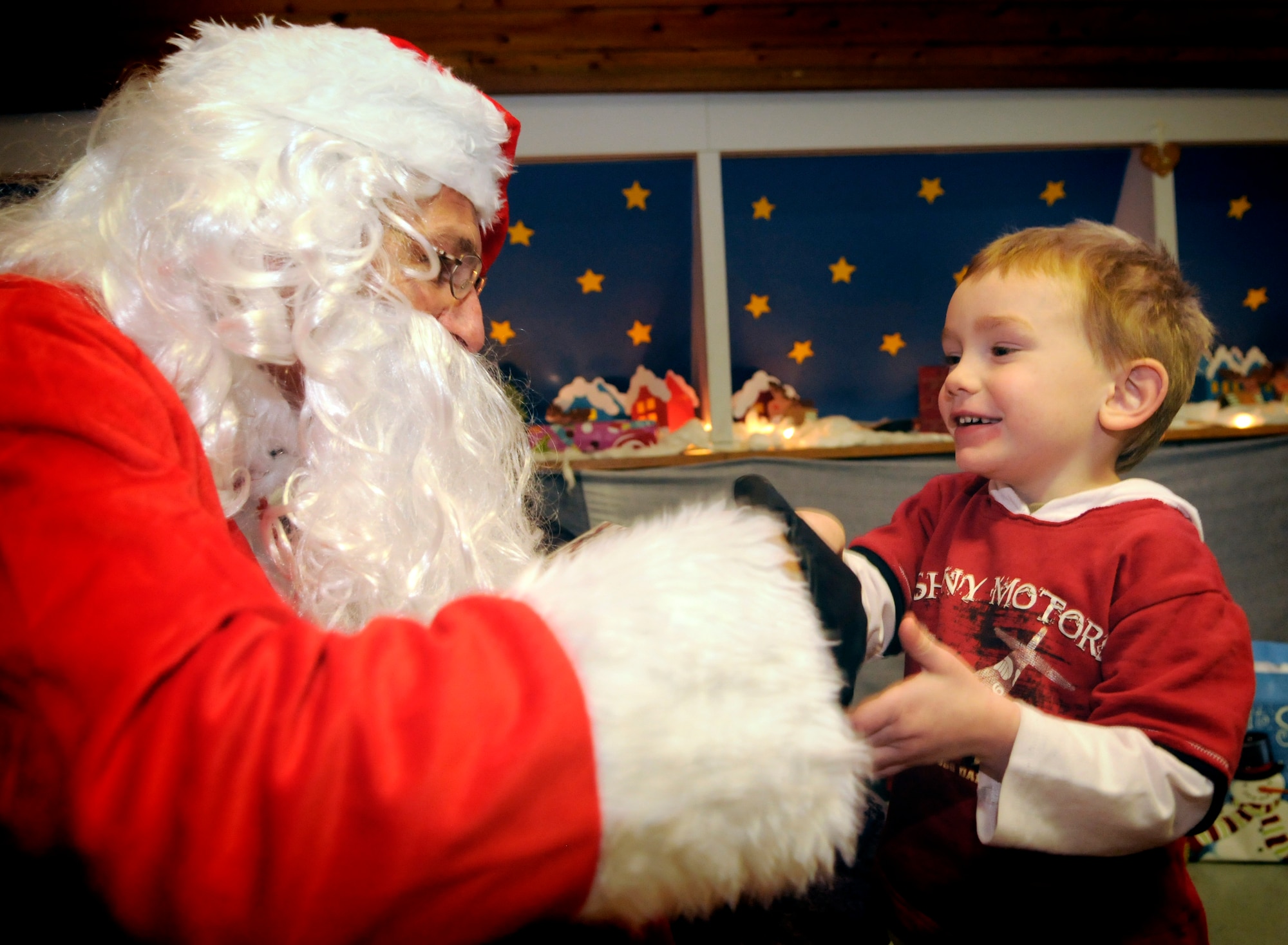 SPANGDAHLEM AIR BASE, Germany –Tech. Sgt. Keith Combass, 52nd Security Forces Squadron, dressed as Santa, gives a gift to Anthony Hopp during a Christmas party Dec. 18 at the St. Vinzenshaus Orphanage in Speicher, Germany. The 52nd Security Forces Squadron donated 60 gifts to the orphanage to help the children celebrate Christmas. The 52nd SFS has been donating gifts to St. Vinzenshaus twice a year for the past three years. (U.S. Air Force photo/Senior Airman Benjamin Wilson)