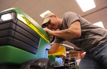MOODY AIR FORCE BASE, Ga. -- Staff Sgt. Jason Chavies, 23rd Equipment Maintenance Squadron HH-60G Pave Hawk crew chief, puts the finishing touches on a child’s toy tractor here Dec. 16. This gift is just one of the hundreds of items donated by Moody members to support the Adopt-a-Family program. (U.S. Air Force photo by Airman 1st Class Benjamin Wiseman)