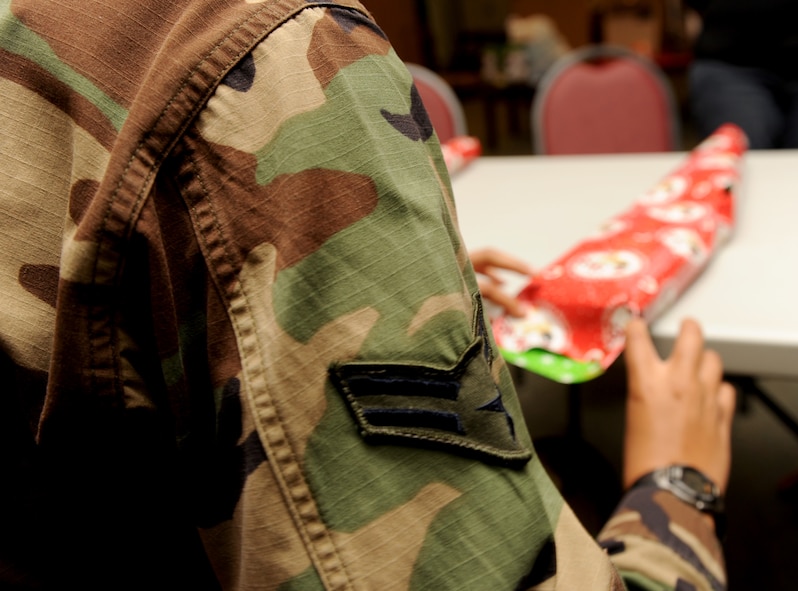 MOODY AIR FORCE BASE, Ga. -- Airman 1st Class Wakia Meadows, 23rd Medical Group medical technician, wraps a present for the Adopt-a-Family program here Dec. 16. Airman Meadows, along with 50 other Moody members, volunteered their time to help wrap gifts that will be donated to 60 different families in need this holiday season. (U.S. Air Force photo by Airman 1st Class Benjamin Wiseman)
