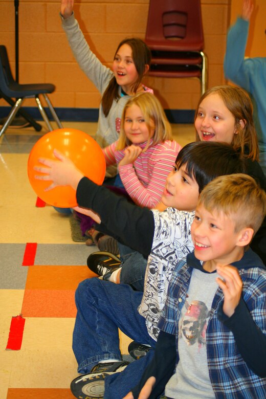 Third-, fourth- and fifth-grade students at West Elementary School in Colorado Springs observe how liquid nitrogen affects a balloon during a "Physics is Phun" event held at the school by the Air Force Academy's Physics Department Dec. 11. The balloon freezes and shrinks in the minus-320-degree liquid and reinflates at room temperature, causing snow to form inside the balloon. (U.S. Air Force photo courtesy of Julie Imada)