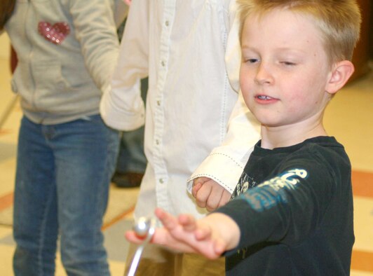 West Elementary School third grader Annione Platten reaches to close a human circuit at a recent "Physics is Phun" event sponsored by the Air Force Academy Dec. 11, 2009. "Physics is Phun" is an education outreach program run by the Academy's Physics Department to show children how fun physics, science, and mathematics can be. (U.S. Air Force photo courtesy of Julie Imada)
