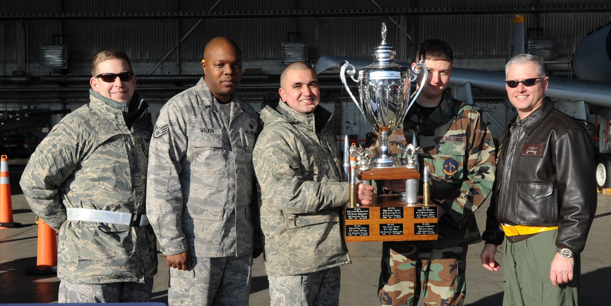 SPANGDAHLEM AIR BASE, Germany –The 81st Aircraft Maintenance Unit accepts the fourth quarter Weapons Load Crew Competition trophy Dec. 18. The 22nd and 81st Fighter Squadrons put together three-man teams and competed against each other to load weapons onto an F-16 Fighting Falcon and an A-10 Thunderbolt II in the fastest time. (U.S. Air Force photo/Airman 1st Class Staci Miller)