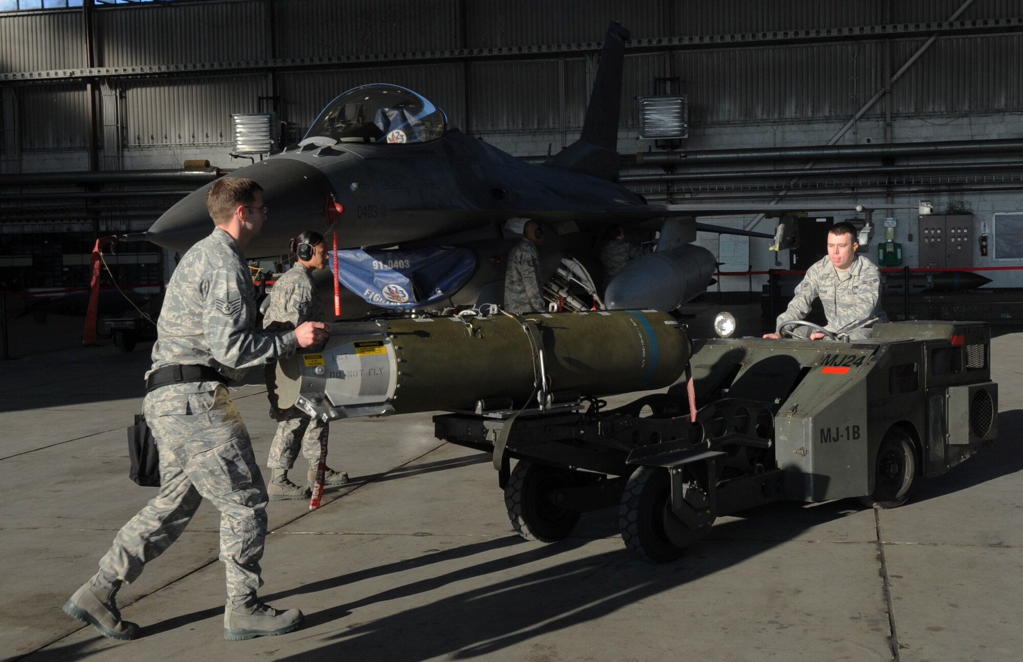 SPANGDAHLEM AIR BASE, Germany – Members from the 22nd Aircraft Maintenance Unit prepare to load a weapon onto an F-16 Fighting Falcon during the fourth quarter Weapons Load Crew Competition Dec. 18. The 22nd and 81st Fighter Squadrons put together three-man teams and competed against each other to load weapons onto an F-16 and an A-10 Thunderbolt II in the fastest time. The 81st FS won the fourth quarter competition. (U.S. Air Force photo/Airman 1st Class Staci Miller)