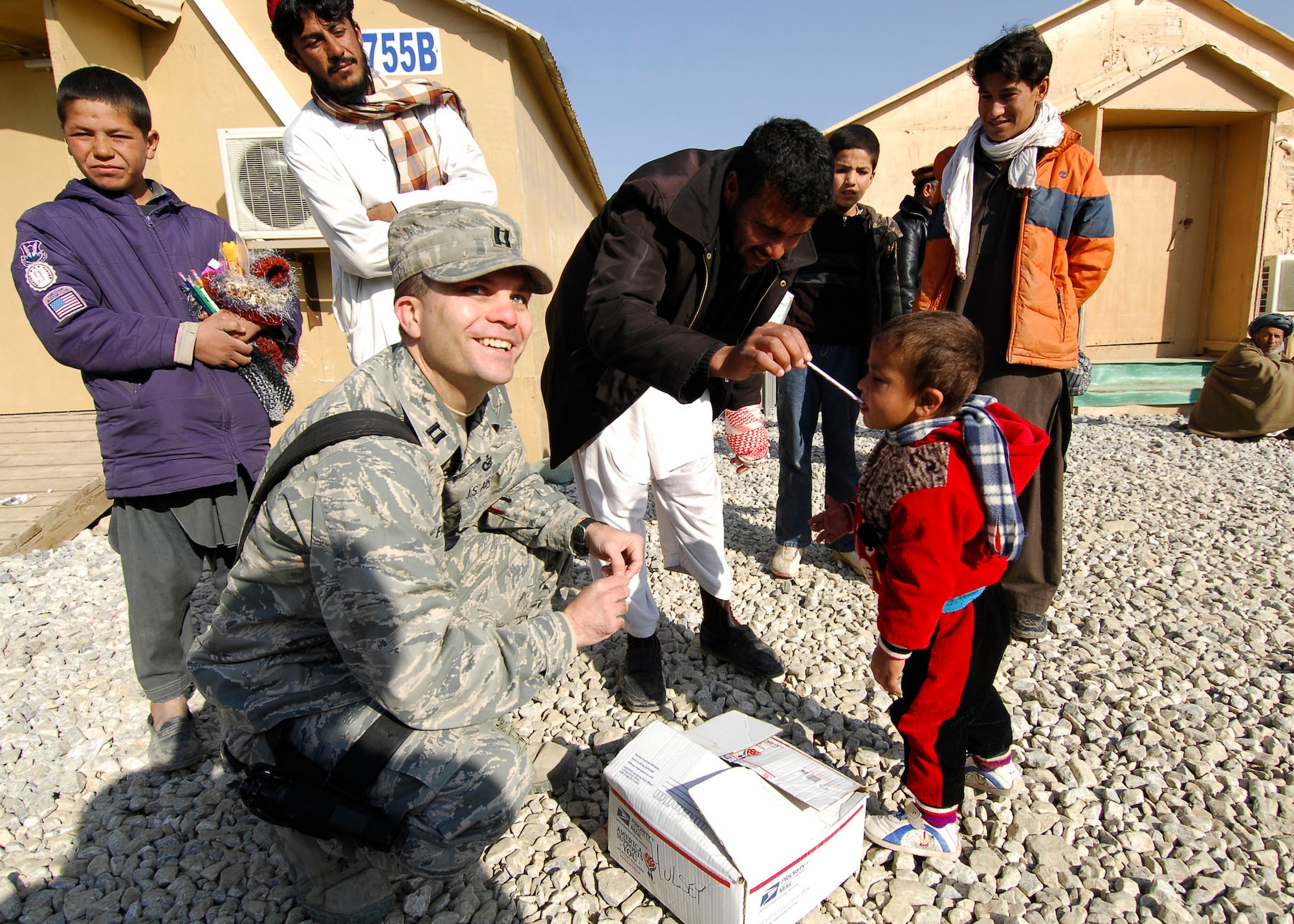 BAGRAM AIRFIELD, Afghanistan -- Captain David Faggard, public affairs officer from the 455th Air Expeditionary Wing, gives candy to an Afghan child during a visit to one of the hospitals on Bagram Airfield, Dec. 21, 2009.  Captain Faggard is deployed from the Pentagon and hails from Mobile, Ala.  (U.S. Air Force photo/Senior Airman Felicia Juenke)