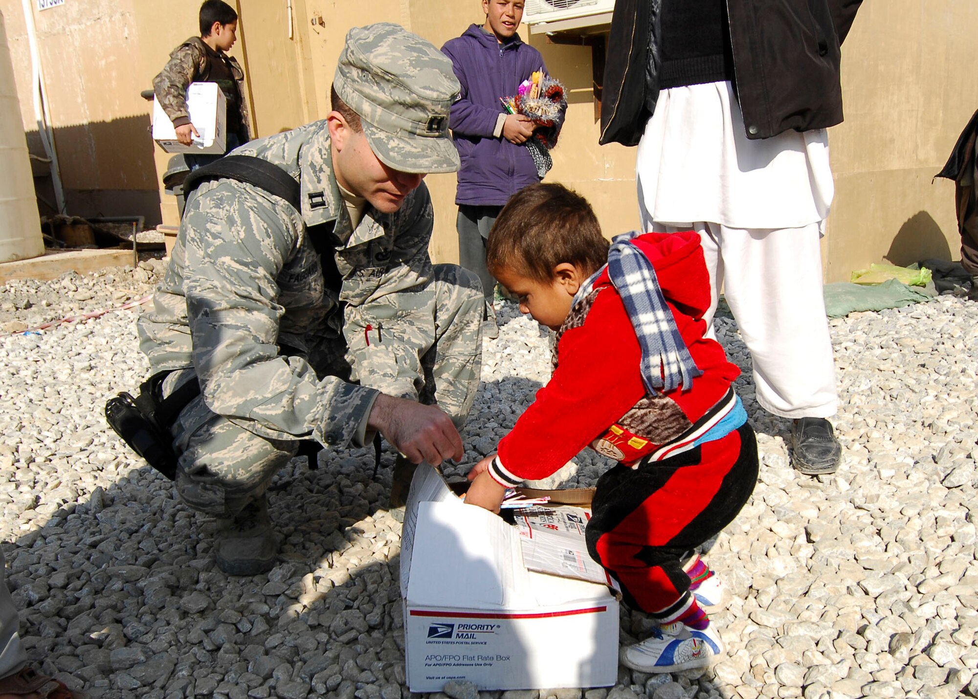 BAGRAM AIRFIELD, Afghanistan -- Captain David Faggard, public affairs officer from the 455th Air Expeditionary Wing, gives candy to an Afghan child during a visit to one of the hospitals on Bagram Airfield, Dec. 21, 2009.  Captain Faggard is deployed from the Pentagon and hails from Mobile, Ala.  (U.S. Air Force photo/Senior Airman Felicia Juenke)