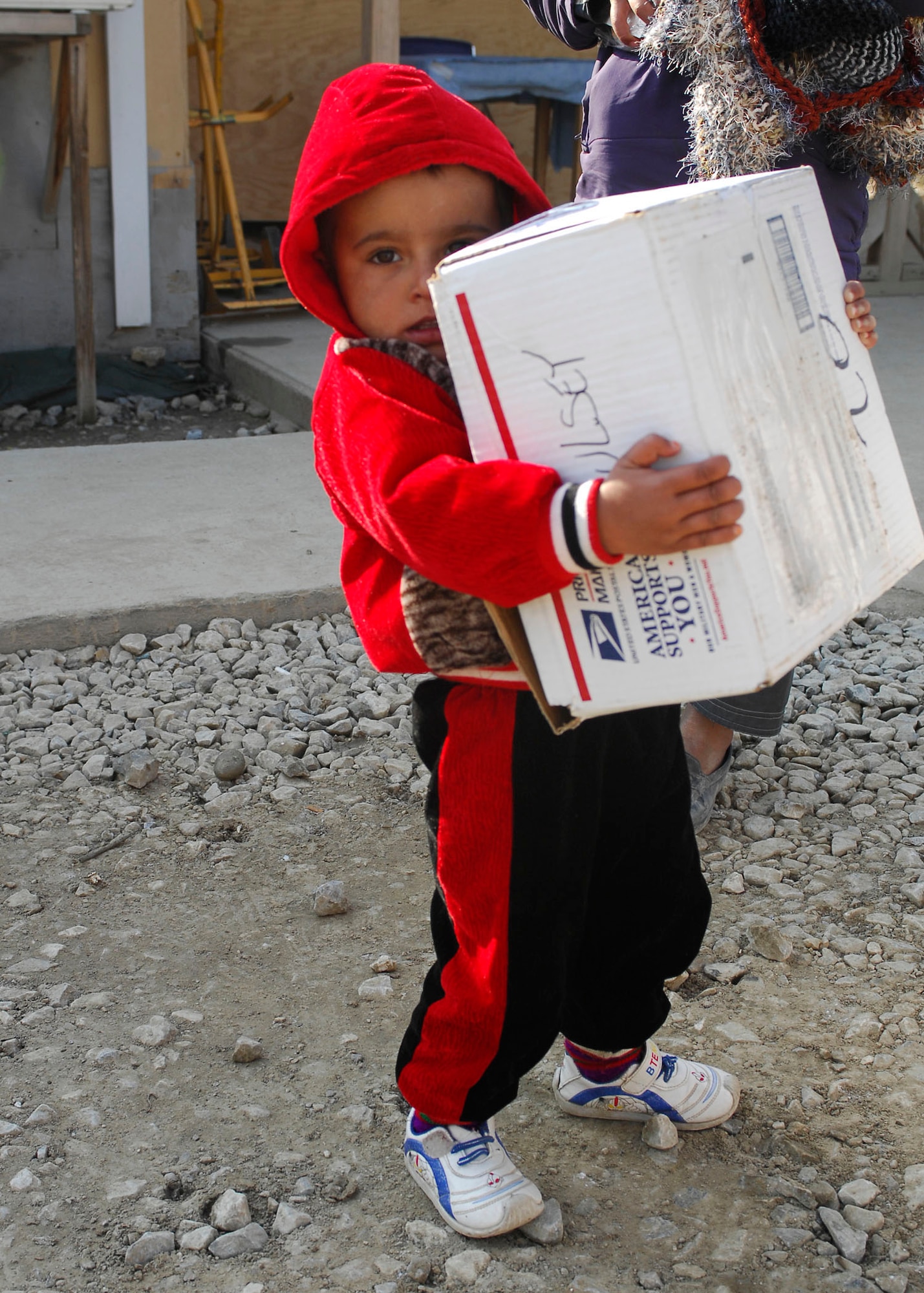 BAGRAM AIRFIELD, Afghanistan -- An Afghan boy clings to his "America Supports You" box full of Hotwheel cars, candy, socks, shoes and other cold weather items, Dec. 21, 2009.  Airmen from the 455th Air Expeditionary Wing visited a hospital here to give supplies out to the Afghans.  The supplies were all donated from Americans whose friends and family members are deployed to Afghanistan.  (U.S. Air Force photo/Captain David Faggard)