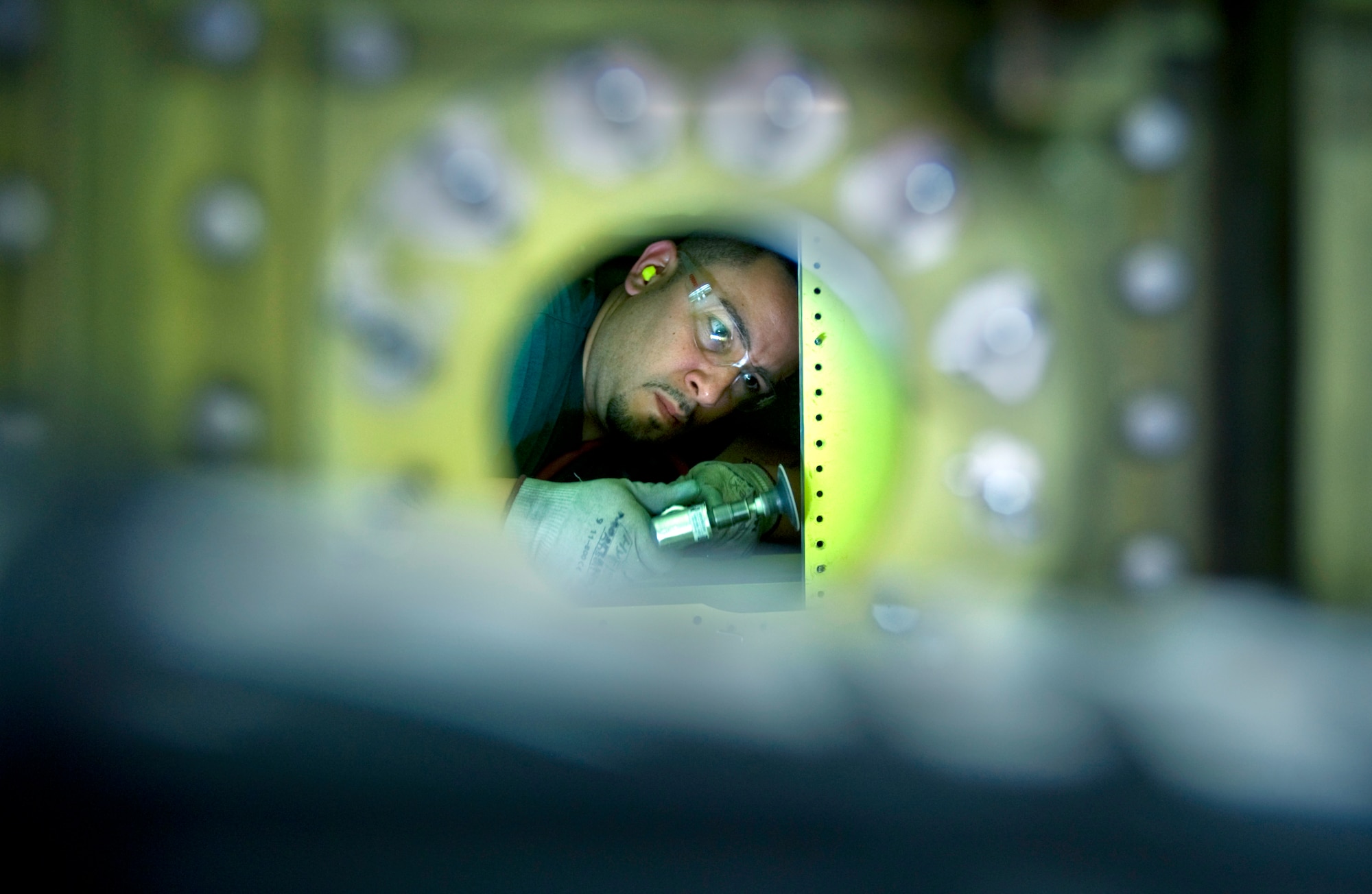 David Montano grinds down the inner web of an A-10 Thunderbolt II wing Dec. 17, 2009.  A-10s are undergoing a wing upgrade at the 309th Aerospace Maintenance and Regeneration Group at Davis-Monthan Air Force Base, Ariz.  The upgrade process, affectionately called the "Hog Up," will make the wings of the tank killer thicker and stronger while increasing the service life of the aircraft another 8,000 hours in the air.  Mr. Montano is an aircraft structural mechanic at the 309th AMARG.  (U.S. Air Force photo/Staff Sgt. Bennie J. Davis III)