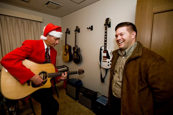 MISAWA AIR BASE, Japan -- Col. David Stilwell, 35th Fighter Wing commander, takes a moment to play the guitar for Master Sgt. Gordon Miller, 35th Operations Support Squadron air traffic control liaison, Dec. 18 during an open house at the Stilwell residence. Members from various units stopped by to share a little bit of Christmas spirit with the Stilwell family. (U.S. Air Force photo/Senior Airman Jamal D. Sutter)