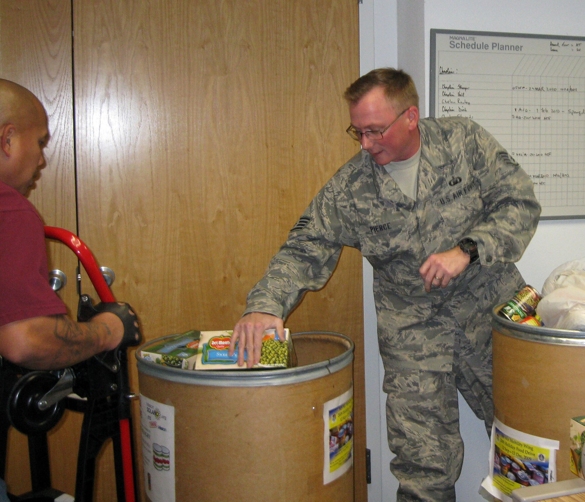 TRAVIS AIR FORCE BASE, Calif. -- The men and women of the 349th Air Mobility Wing have outdone themselves with generous food donations to the 349th Chaplain’s Annual Holiday Food Drive.  Members of the 349th Air Mobility Wing donated more than 5,460 pounds of food to help feed those in need in the local area. Staff Sgt. Michael Pierce, 349th Air Mobility Wing chaplain assistant works, here, with a helper from the local area food bank to get the donations ready to be loaded onto the truck, Dec. 22. (U.S. Air Force photo/Patti Schwab-Holloway) 