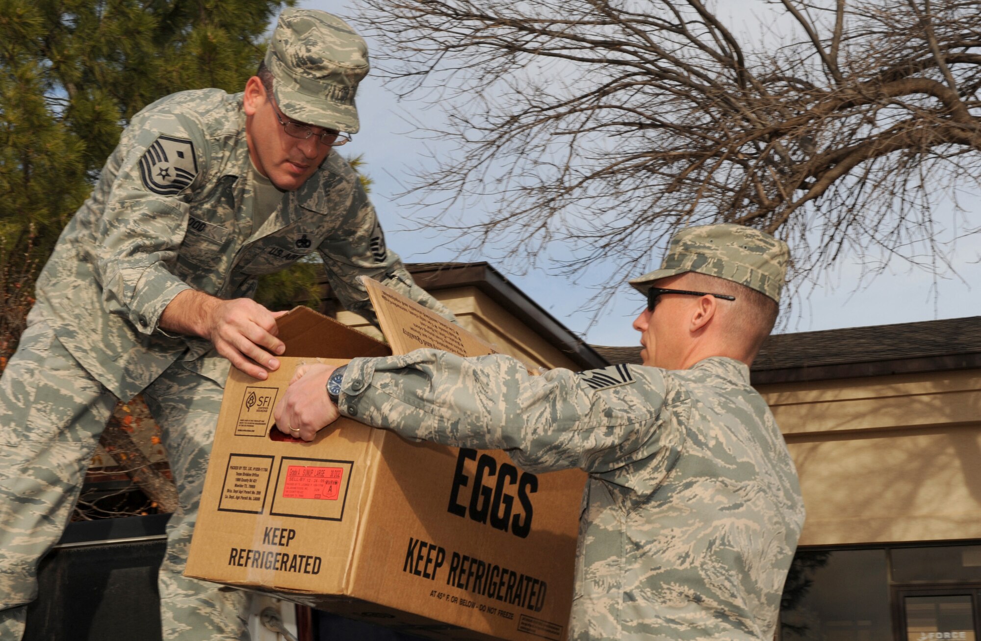 DYESS AIR FORCE BASE, Texas -- First Sgts., Master Sgt. Jerry Hood, 7th Comptroller Squadron, and Senior Master Sgt. Brian Beeksma, 7th Logistics Readiness Squadron, unload donated cookies for the dormitory residents here, Dec. 21.  Every year the First Sgts. collect home made cookies from base members to hand out to the dorm residents during the holiday season.  (U.S. Air Force photo/ Staff Sgt. Tanya Bowen)