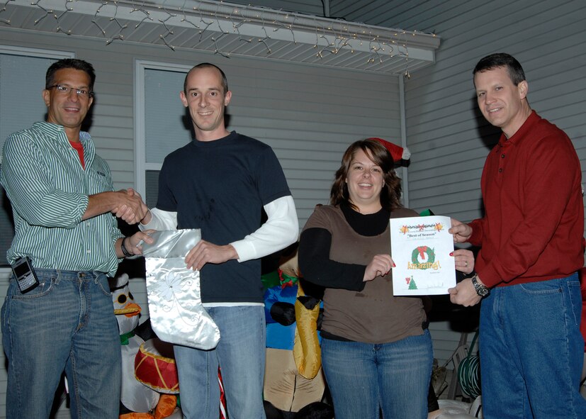 Col. Pat Rose, 22nd Mission Support Group commander, left, and  Col. James Crowhurst, 22nd Air Refueling Wing commander, right present Senior Airman Matthew Cavazos, 22nd Logistics Readiness Squadron, and his wife Julie Cavazos a certificate for winning the title “Best of the Season,” Dec. 16, 2009, for a holiday light and decoration contest at Southwind housing at McConnell Air Force, Kan. Winners of the contest received gift certificates for places such as the base exchange, a local garden center and various 22nd Force Support Squadron services facilities. (U.S. Air Force photo/ Airman 1st Class Justin A. Shelton)