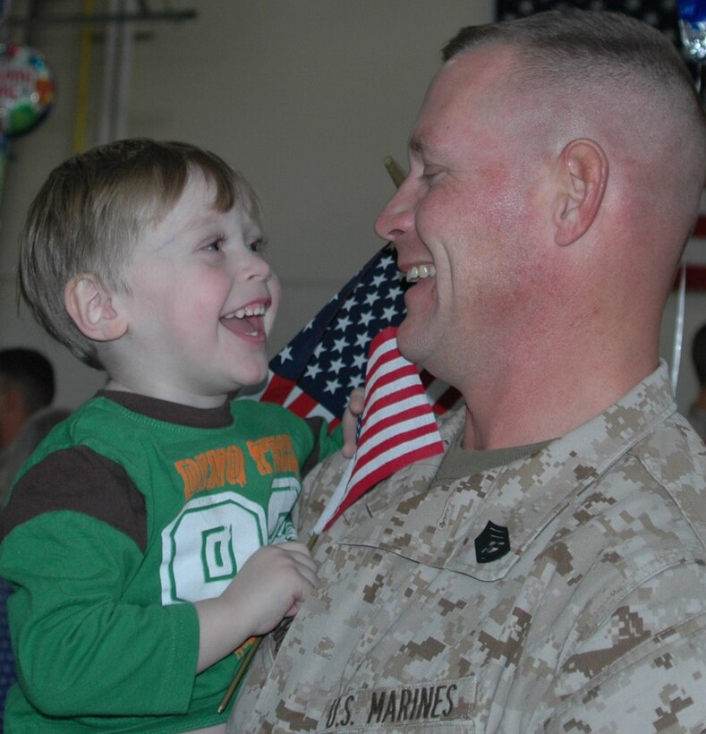 Marine Gunnery Sgt. Tony Rozbora of Lenox, Mass., is all smiles with his son during their reunion Dec. 20 at Westover. The Marine reservist was among more than 40 who returned from a deployment to Iraq. (US Air Force photo/Tech. Sgt. Andrew Biscoe)