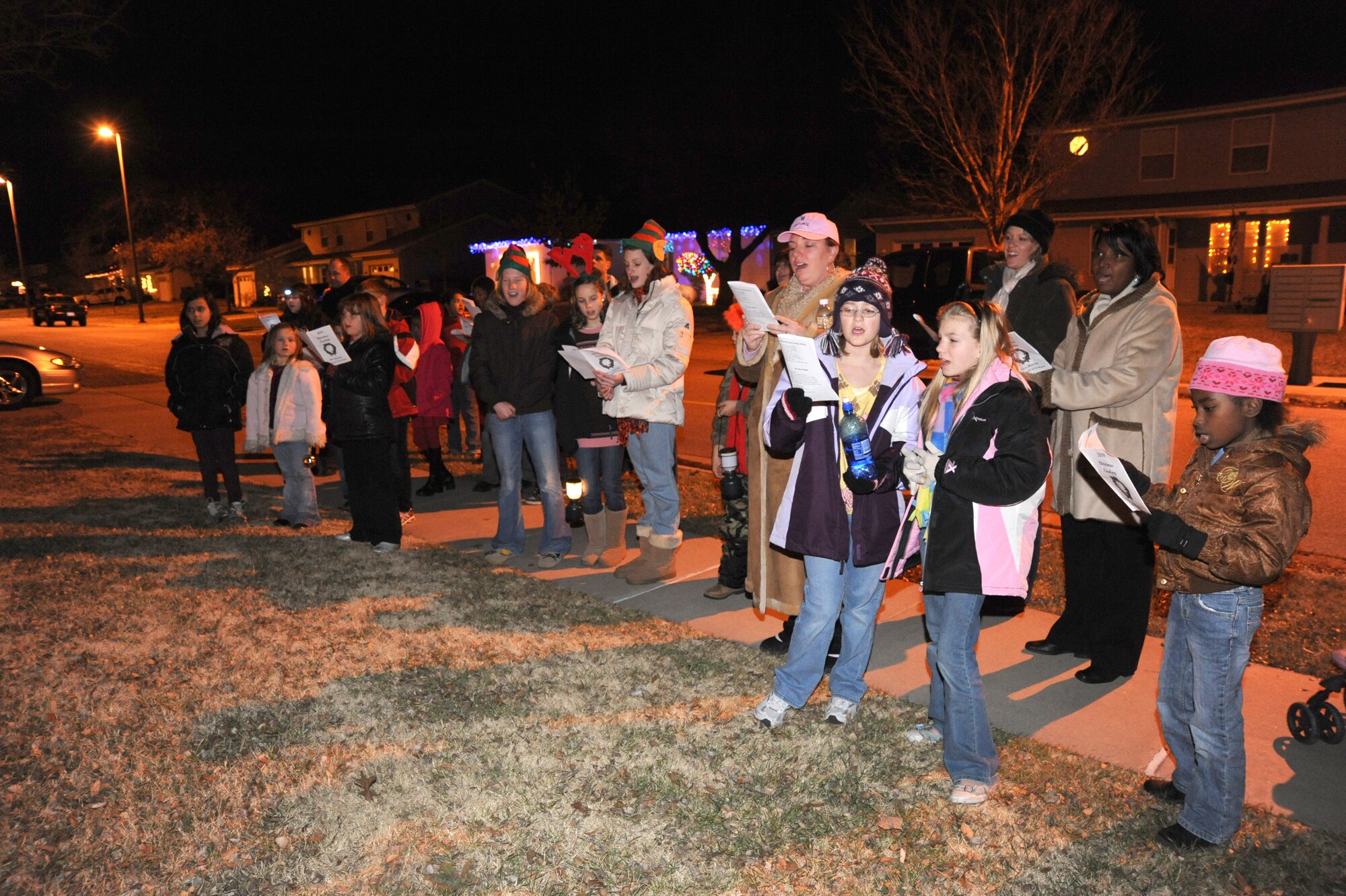 Team McConnell members sing holiday carols at Southwind base housing to celebrate the holiday season at McConnell Air Force Base, Kan., Dec. 20, 2009. The base chapel hosted the caroling event as a Year of the Air Force Family initiative, with more than 80 Team McConnell members participated. (U.S. Air Force photo by Tech. Sgt. Chyrece Campbell)