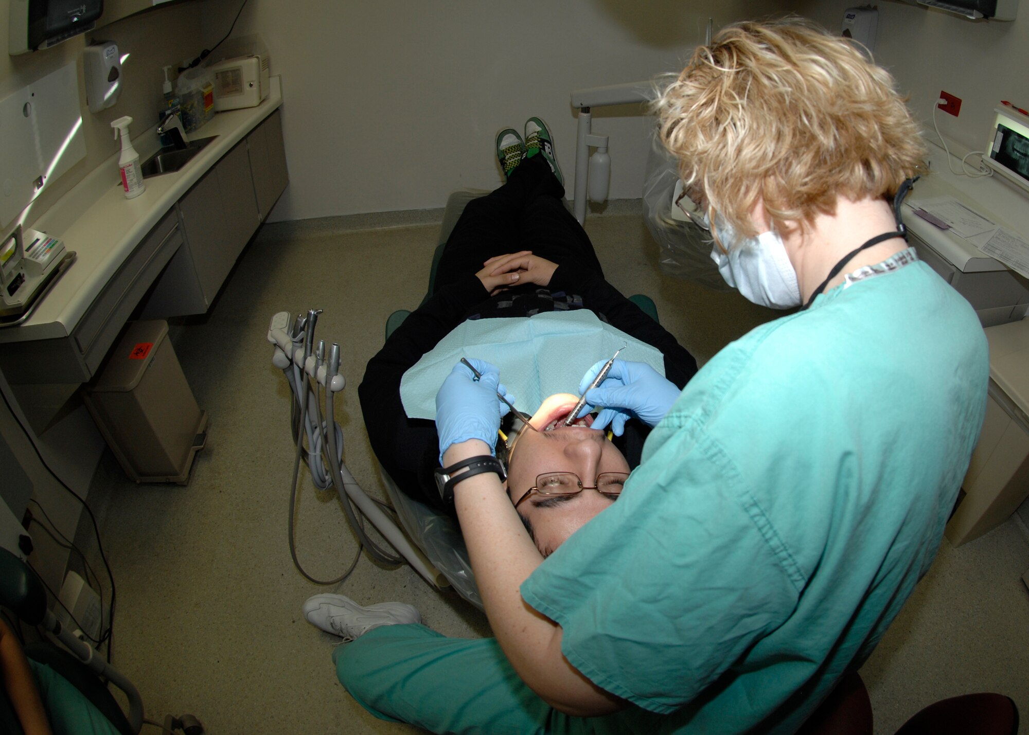 Capt. Kelly Raimi, a 22nd Aero-Medical Dental Squadron dentist, performs an evaluation on Airman 1st Class Rodolfo Quiroz, 22nd Maintenance Squadron, Dec. 14, 2009, McConnell Air Force Base, Kan. (U.S. Air Force Photo by Airman 1st Class Justin Shelton)