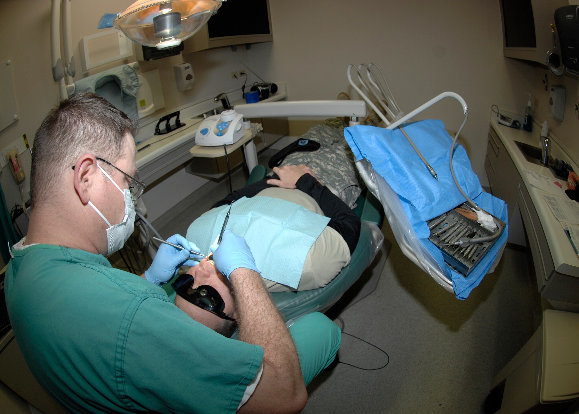 Master Sgt. Dennis Sunderland, a 22nd Aero-Medical Dental Squadron dental assistant, performs routine dental cleaning, Dec. 14, 2009, on Army Capt. Dana Graf, at McConnell Air Force Base, Kan. Sergeant Sunderland processes records, cleans teeth and helps dentists during procedures. (U.S. Air Force Photo by Justin A. Shelton)