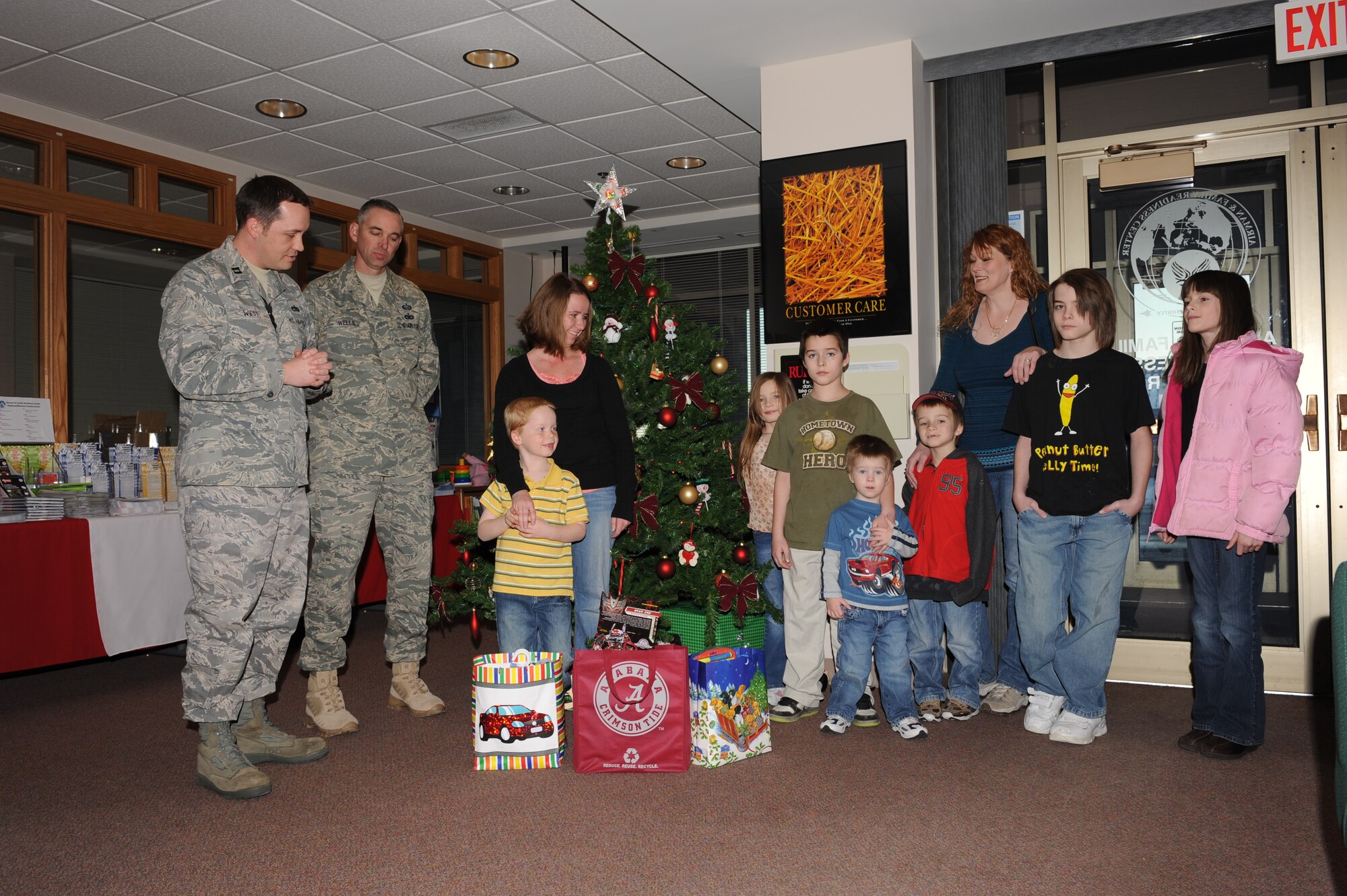 ELLSWORTH AIR FORCE BASE, S.D. -- Alexander Roper (center-yellow-shirt) son of Staff Sgt. Andrew Roper, 28th Logistic Readiness Squadron fuels accountant, donates his birthday presents to an Ellsworth family at the Airman Family and Readiness center, Dec. 18. Alexander decided that since his birthday was so close to Christmas, he would get enough presents from Santa, so he chose to donate his birthday presents to another family. (U.S. Air Force photo/ Master Sgt. Loren J. Bonser)