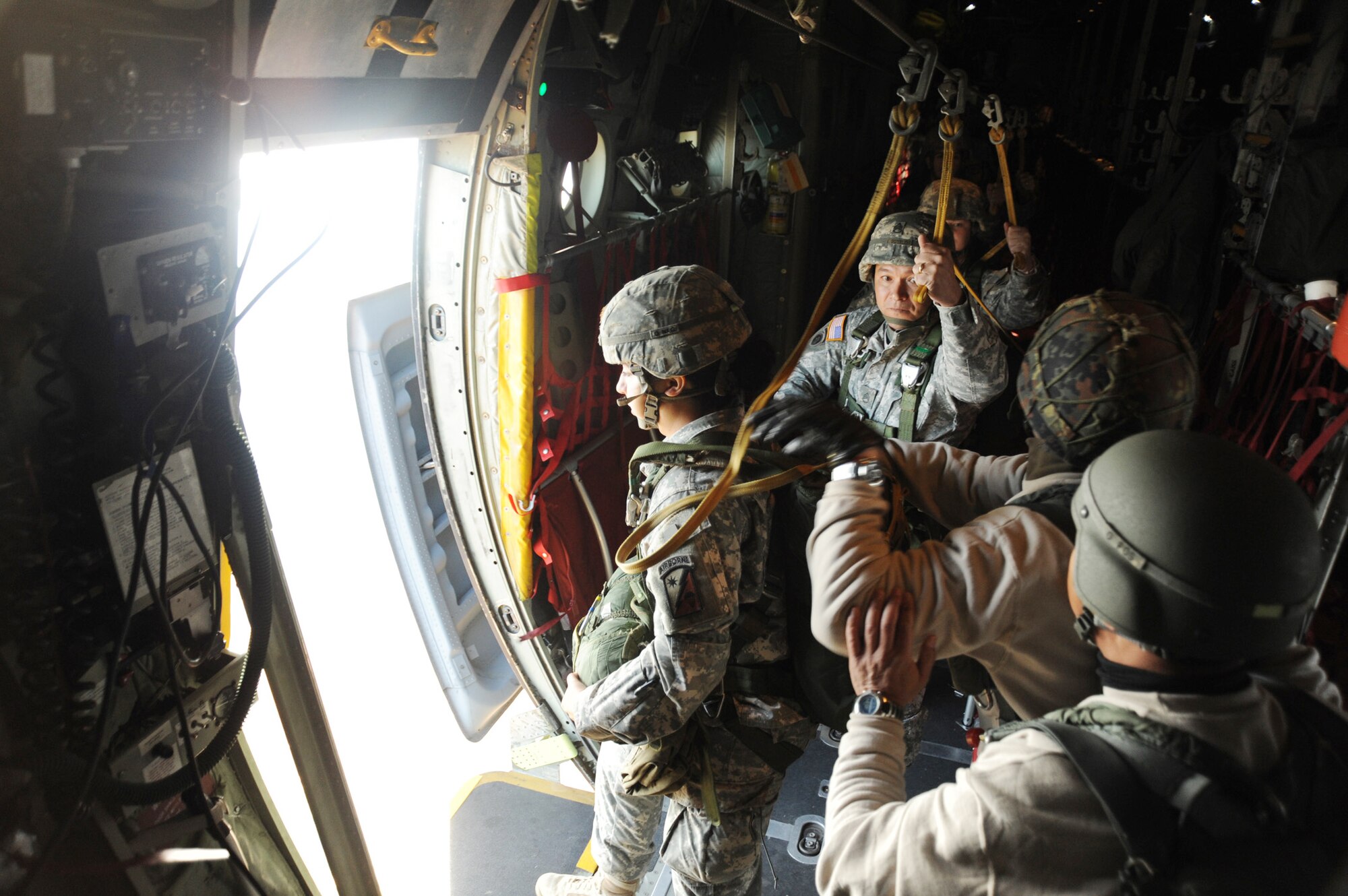 The first paratrooper to jump waits for the "green light" on board a C-130 Hercules Dec. 6, 2009, above Fort Bragg's Sicily Drop Zone in North Carolina. Crews from the National Guard's 145th Airlift Wing from Charlotte, N.C., and the Air Force Reserve's 910th Airlift Wing from Youngstown, Ohio, participated in the 12th Annual Randy Oler Operation Toy Drop event. (U.S. Air Force photo/Senior Airman Peter Miller)