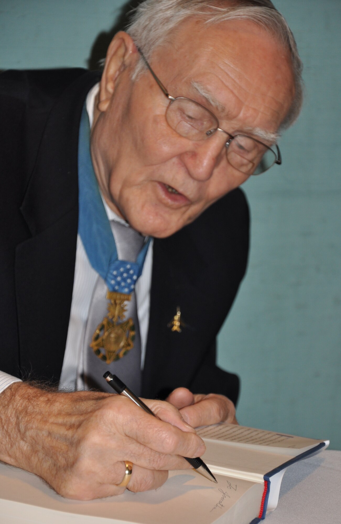 Col. (ret.) Bud Day, 30-year combat veteran and former prisoner of war,  autographs his latest book after his talk to Eglin's Junior Force Council about the memoirs he penned. The council's overall mission to provide junior-level military members and civilians with professional and career development was acheived recently by reading several recommended publications. (U.S. Air Force photo/Ashley Wright)