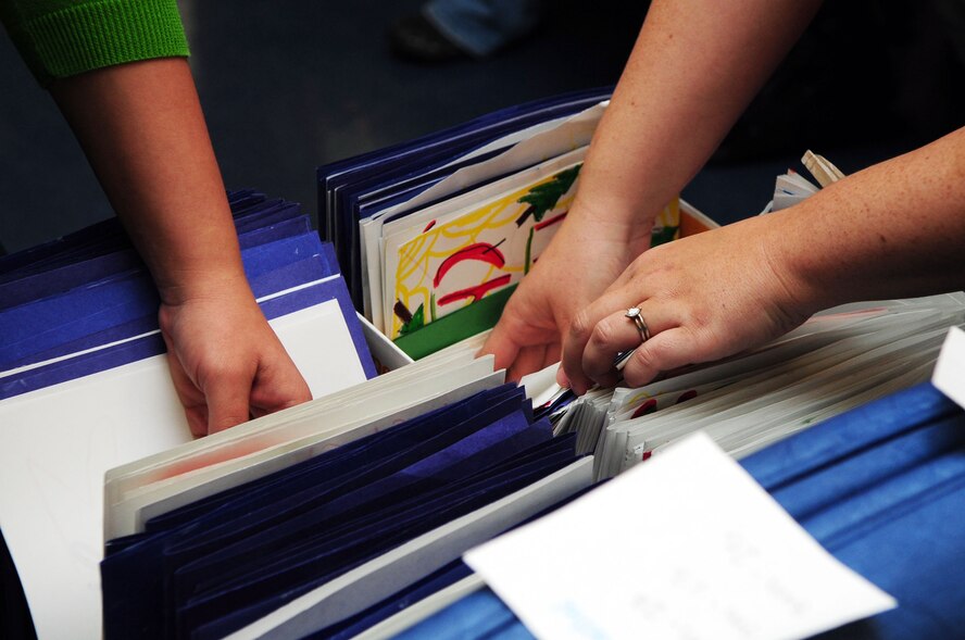 SHREVEPORT, La. – Capt. Timothy Tryon, 20th Bomb Squadron, and his wife Jenny deliver Christmas cards to Larry Bush, an Army Vietnam Veteran at the Overton Brooks Veterans Affairs Hospital Dec. 19. The cards were collected by the Barksdale Air Force Base Enlisted Spouses Group from base and local community drop boxes, and delivered by the BESG, Airmen and their families. (U.S. Air Force photo by Senior Airman Joanna M. Kresge) 